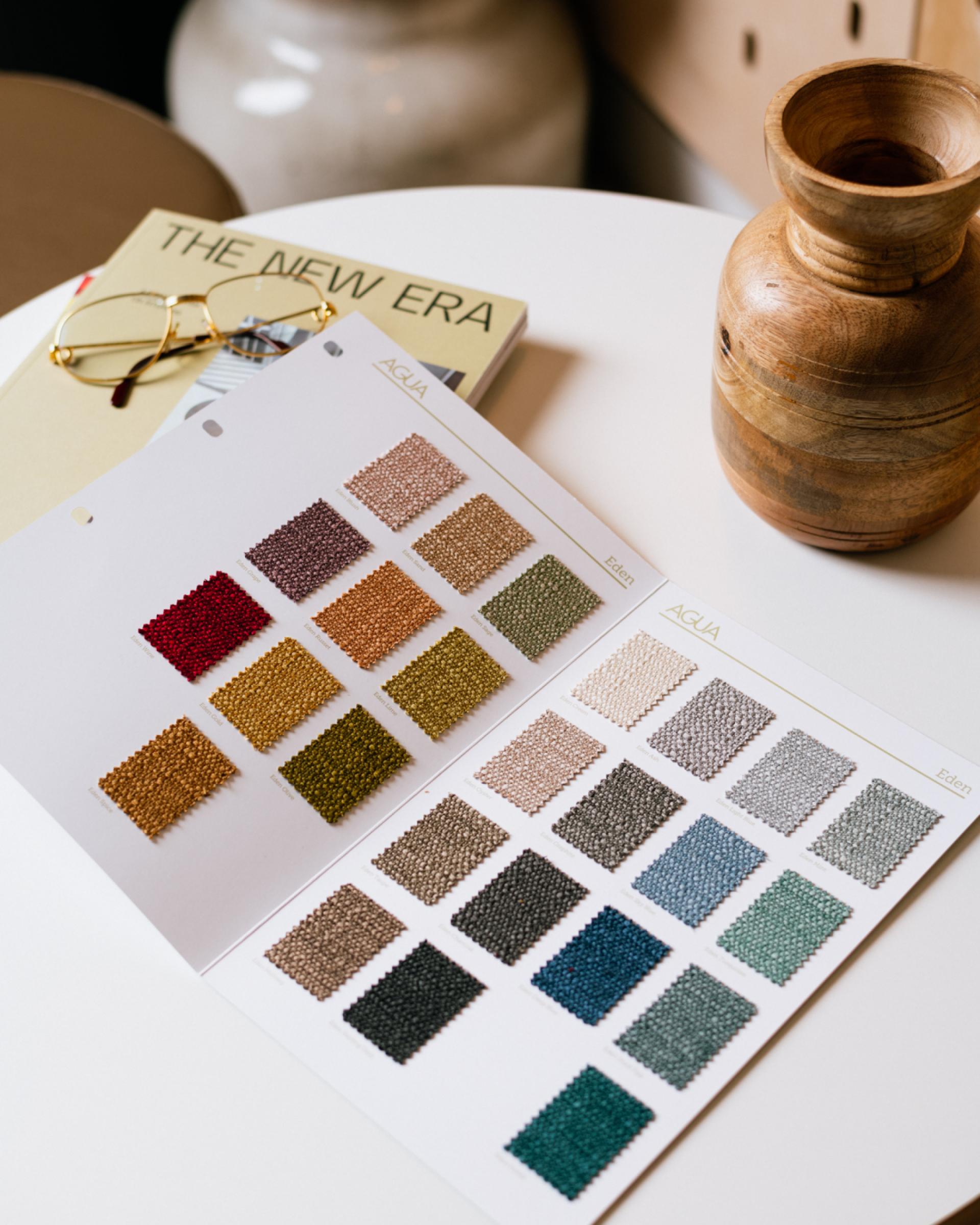 Fabric swatches in various colors displayed on a table with design books, highlighting Material Source Studio’s textile selection in Glasgow.