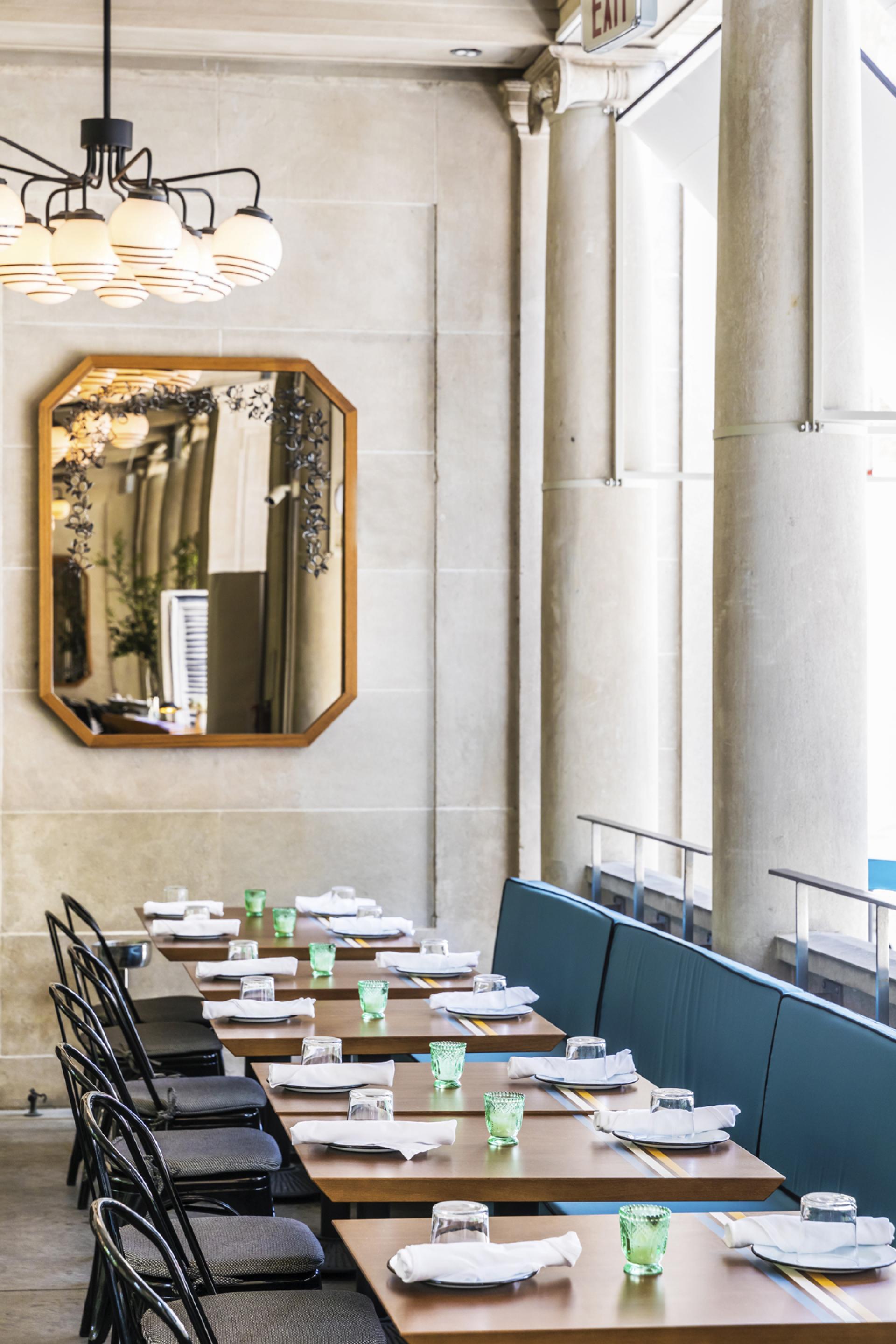 Modern restaurant interior of Bocce, featuring stylish tables with green glassware and elegant lighting design by Gachot Studios.