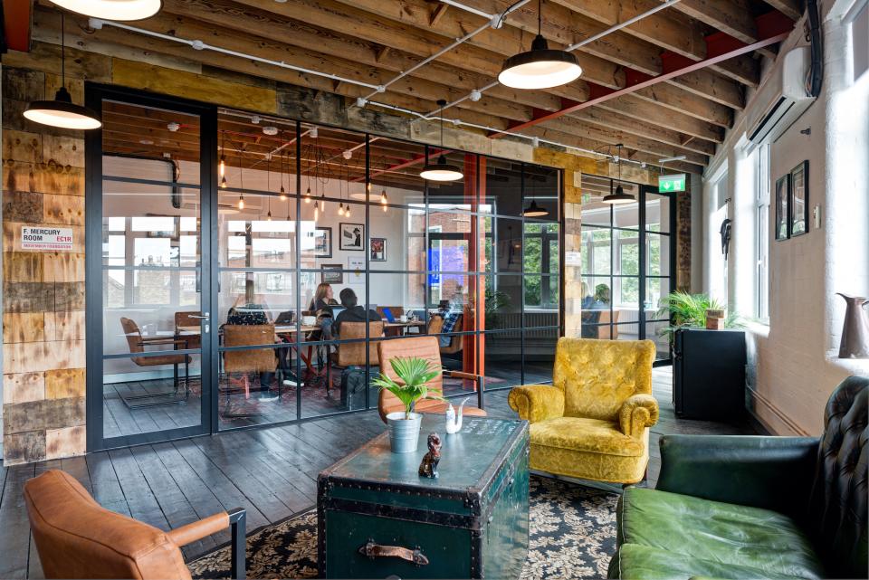 Industrial-style office space redesigned by CCWS Interiors for Movember Foundation, featuring cozy seating and collaborative work areas.