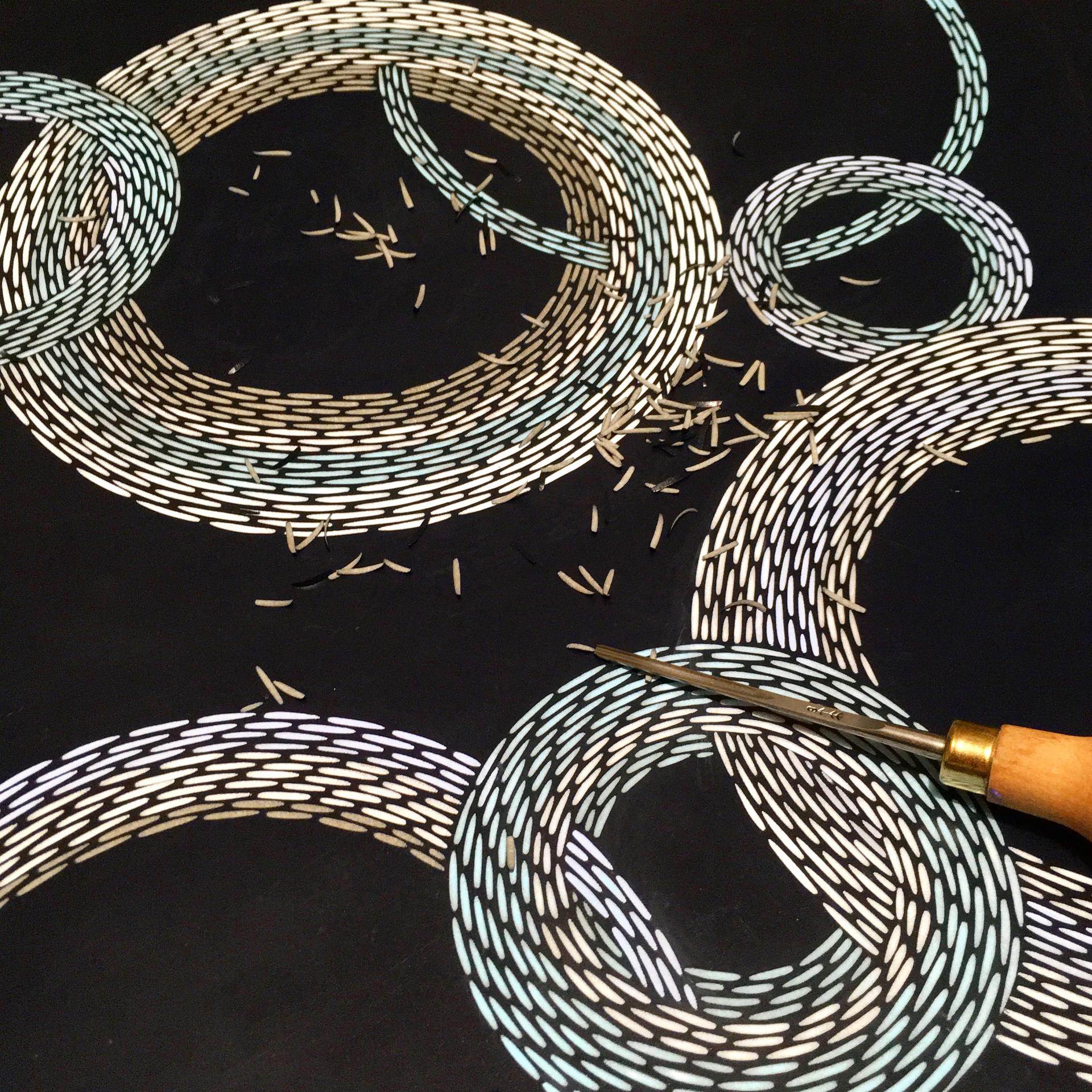 Intricate woven patterns on a black surface with crafting tools, illustrating the artistry of Louisa Pacifico's Future Icons.