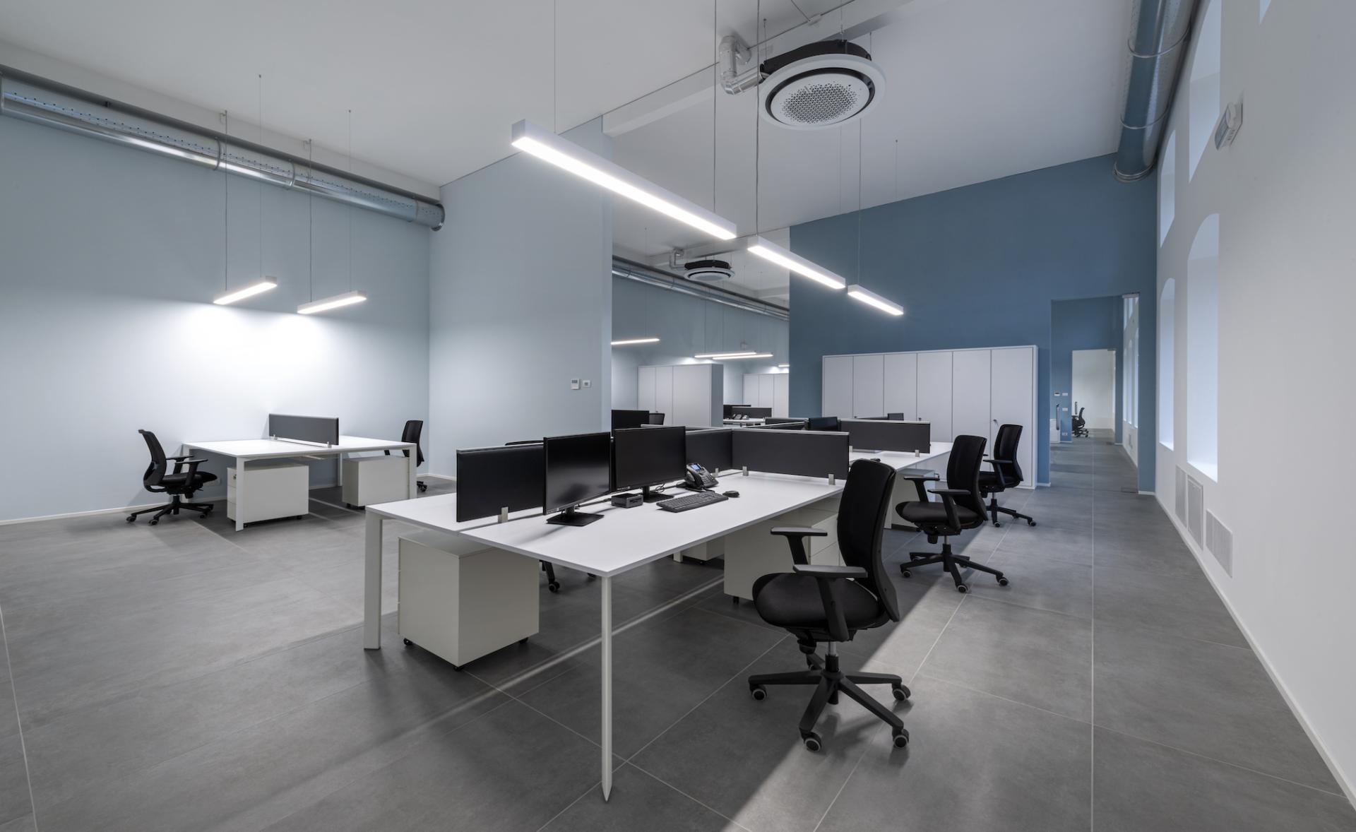 Modern office layout featuring workstations with computers, stylish furniture, and a bright, airy ambiance in T&T's headquarters.