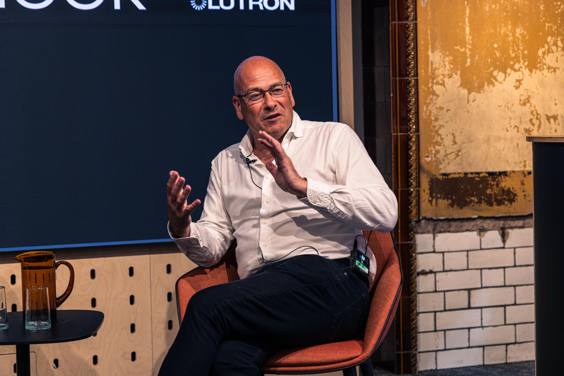 Speaker discussing Manchester property growth trends at Material Source Studio seminar, with creative studio backdrop and audience engagement.