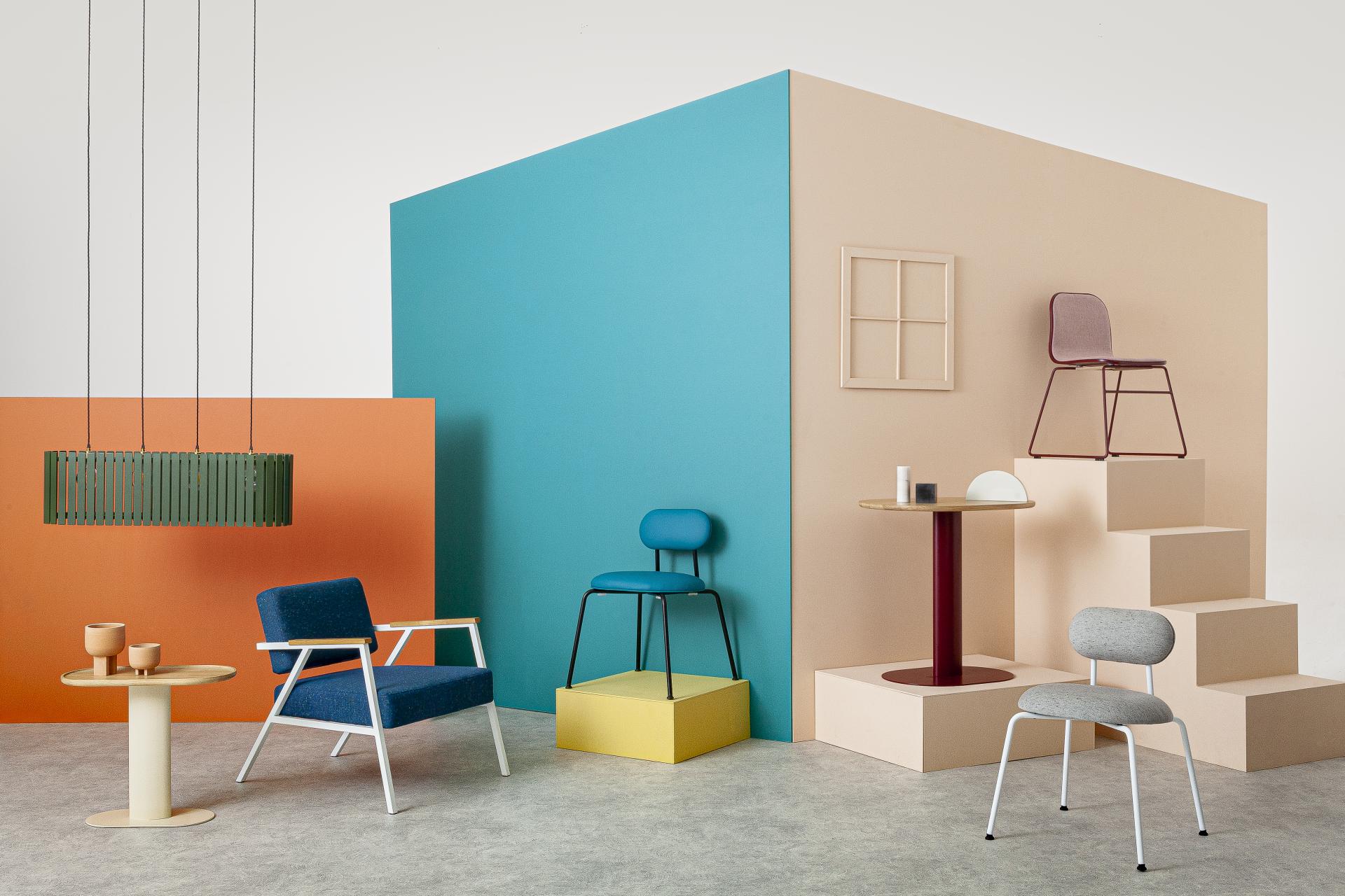 Colorful display of modern furniture and lighting by Liqui Contracts showcased against vibrant backdrops at 100% Design.