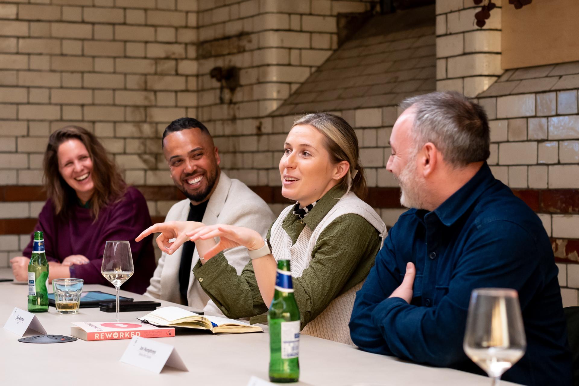 Group discussion on EDI cultural initiatives at Material Source Studio, featuring participants engaged and sharing ideas over drinks.
