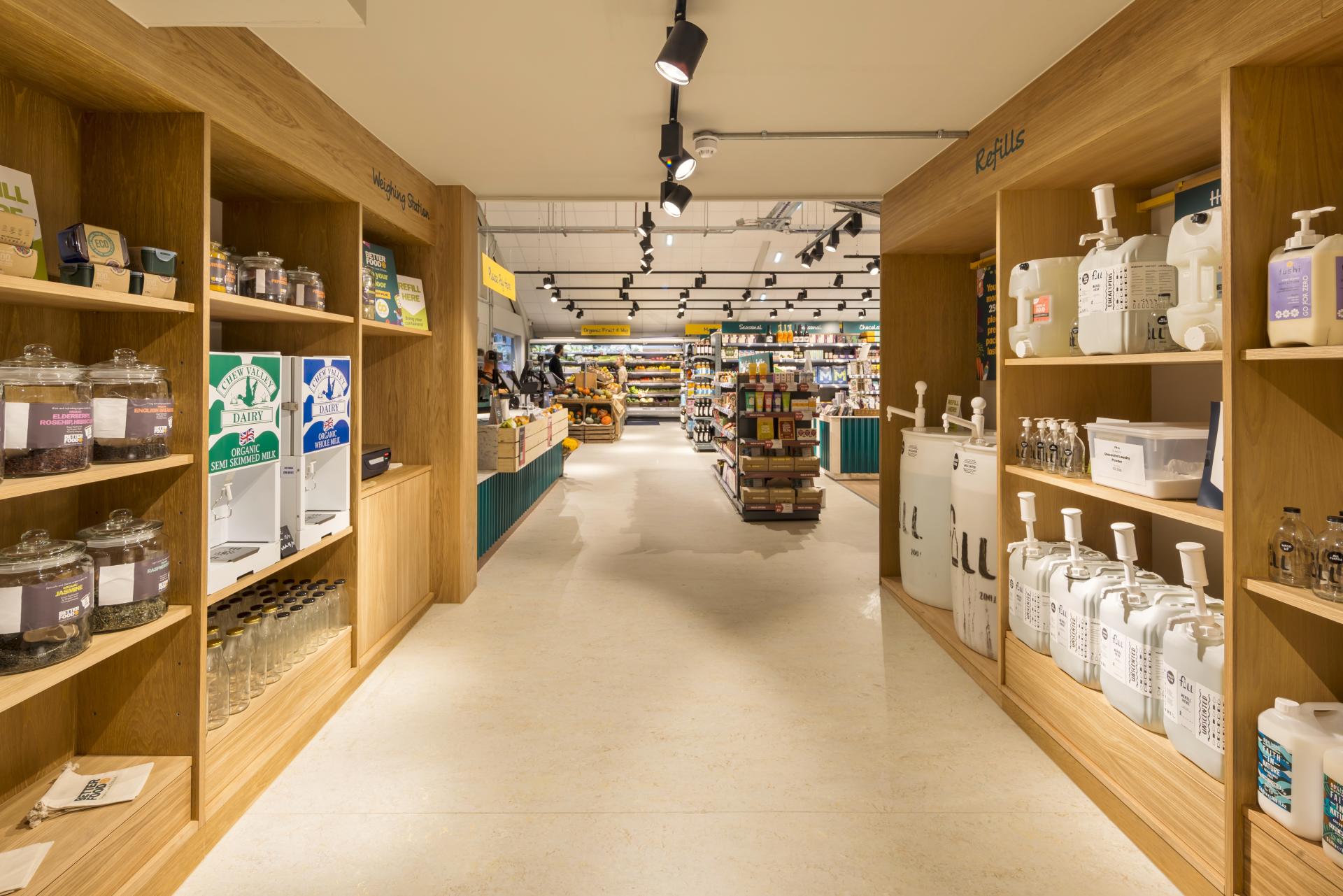 Brightly lit interior of Better Food's new Gloucester Road store, featuring display shelves with organic products and a café-deli area.