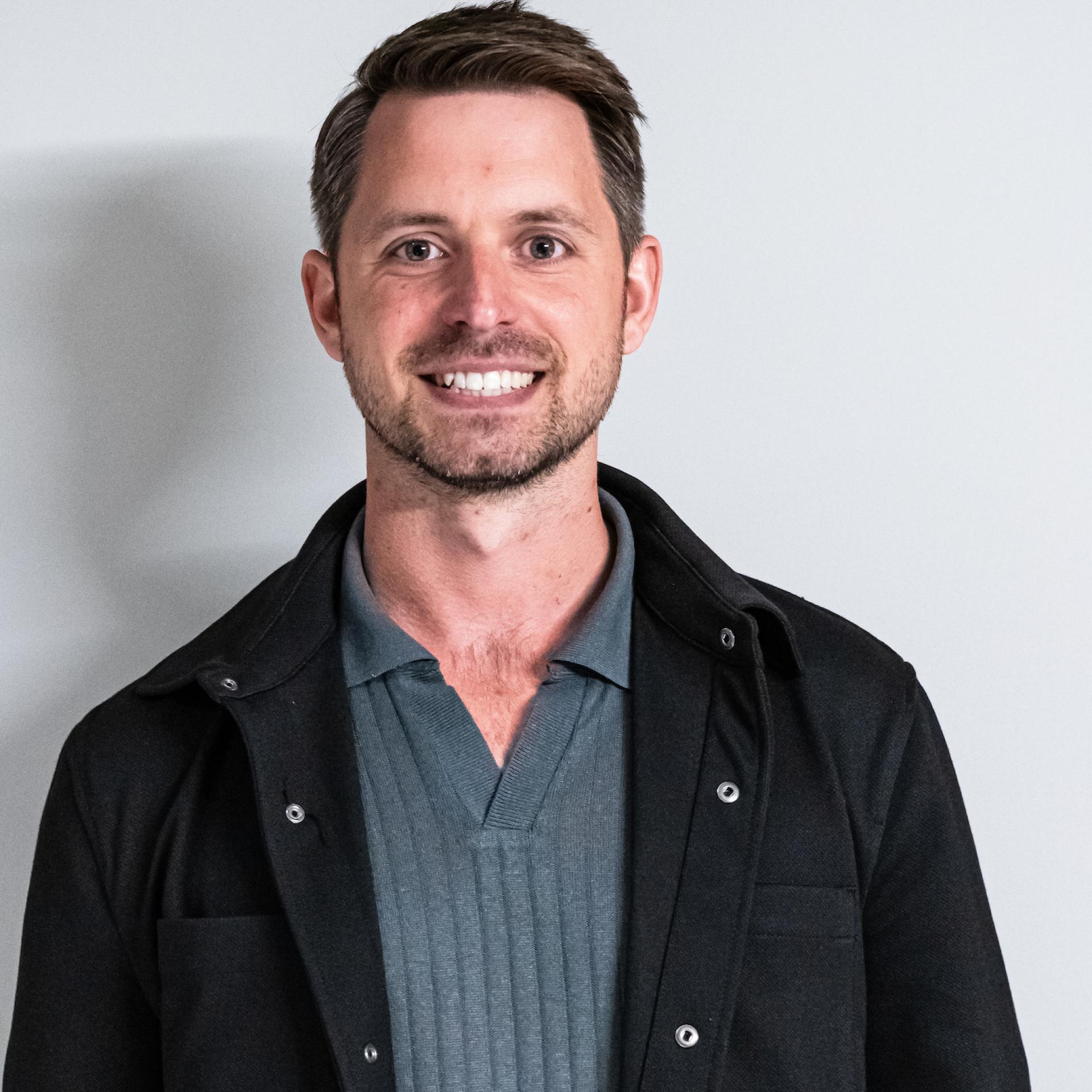 Professional man smiling, representing Manchester's evolving property sector and the rise of co-living developments.