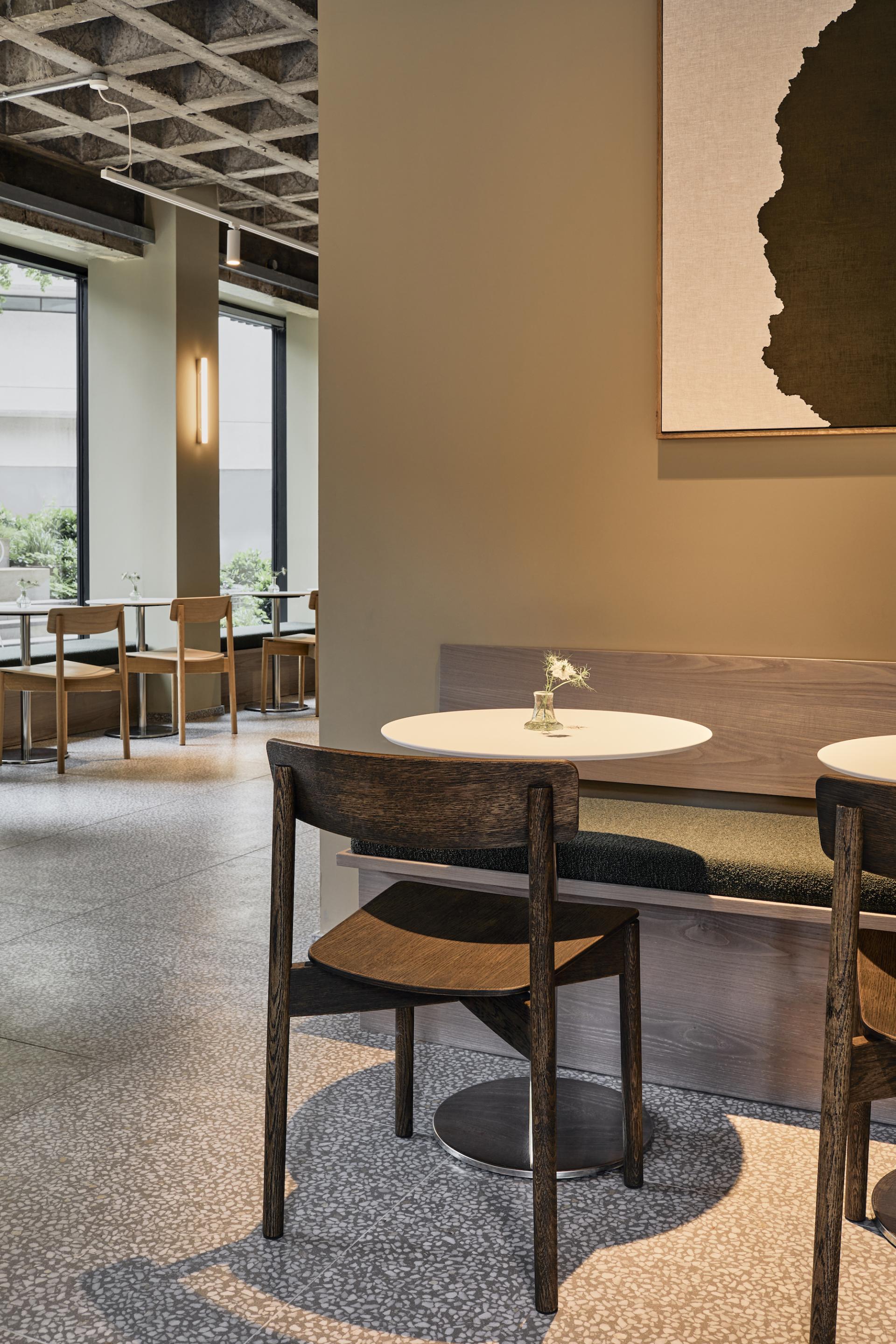 Modern café interior featuring minimalistic design, wooden furniture, and natural light highlighting a cozy atmosphere.