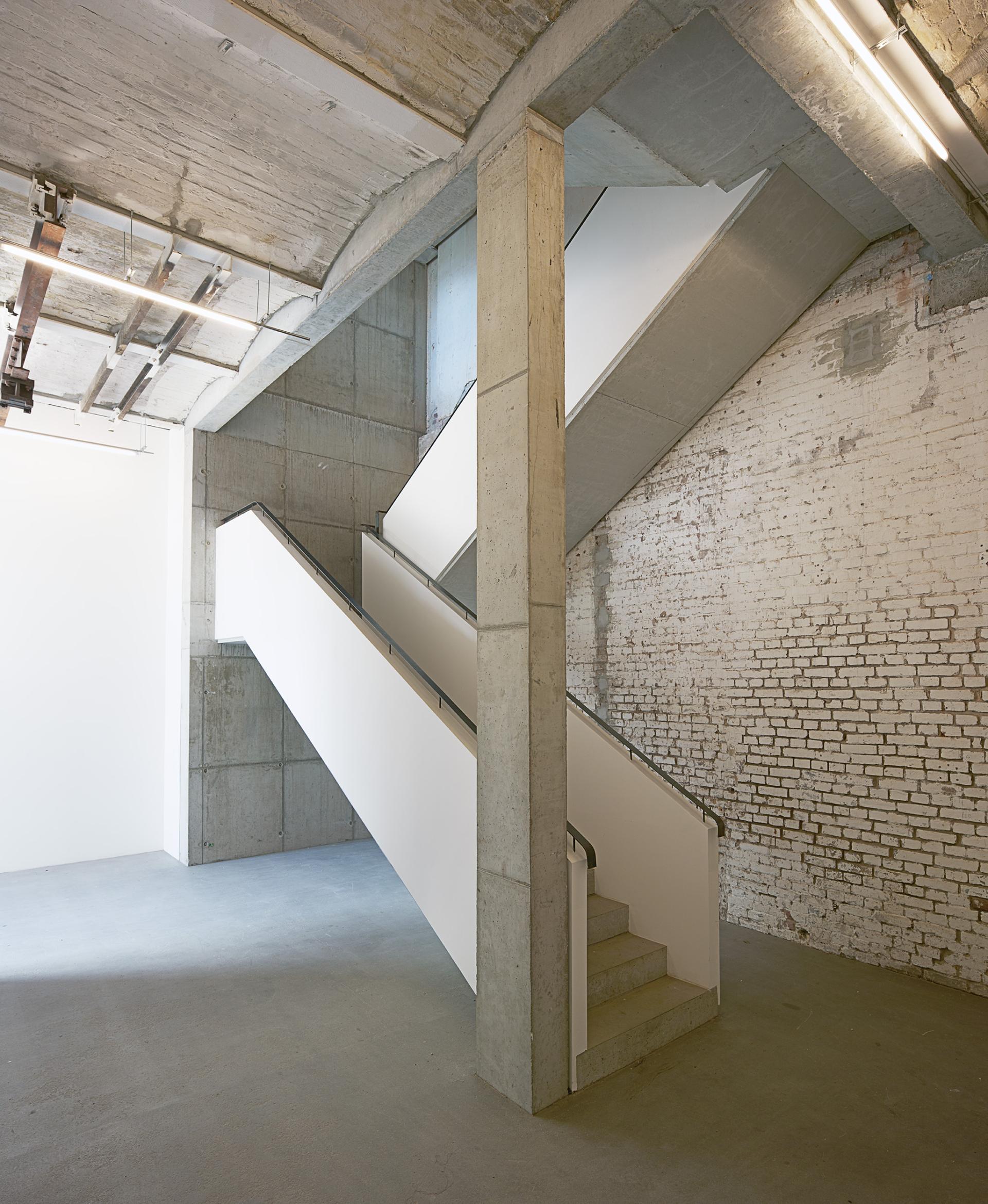 Modern concrete staircase in redeveloped industrial space, highlighting the architectural transformation at Lindower 22.