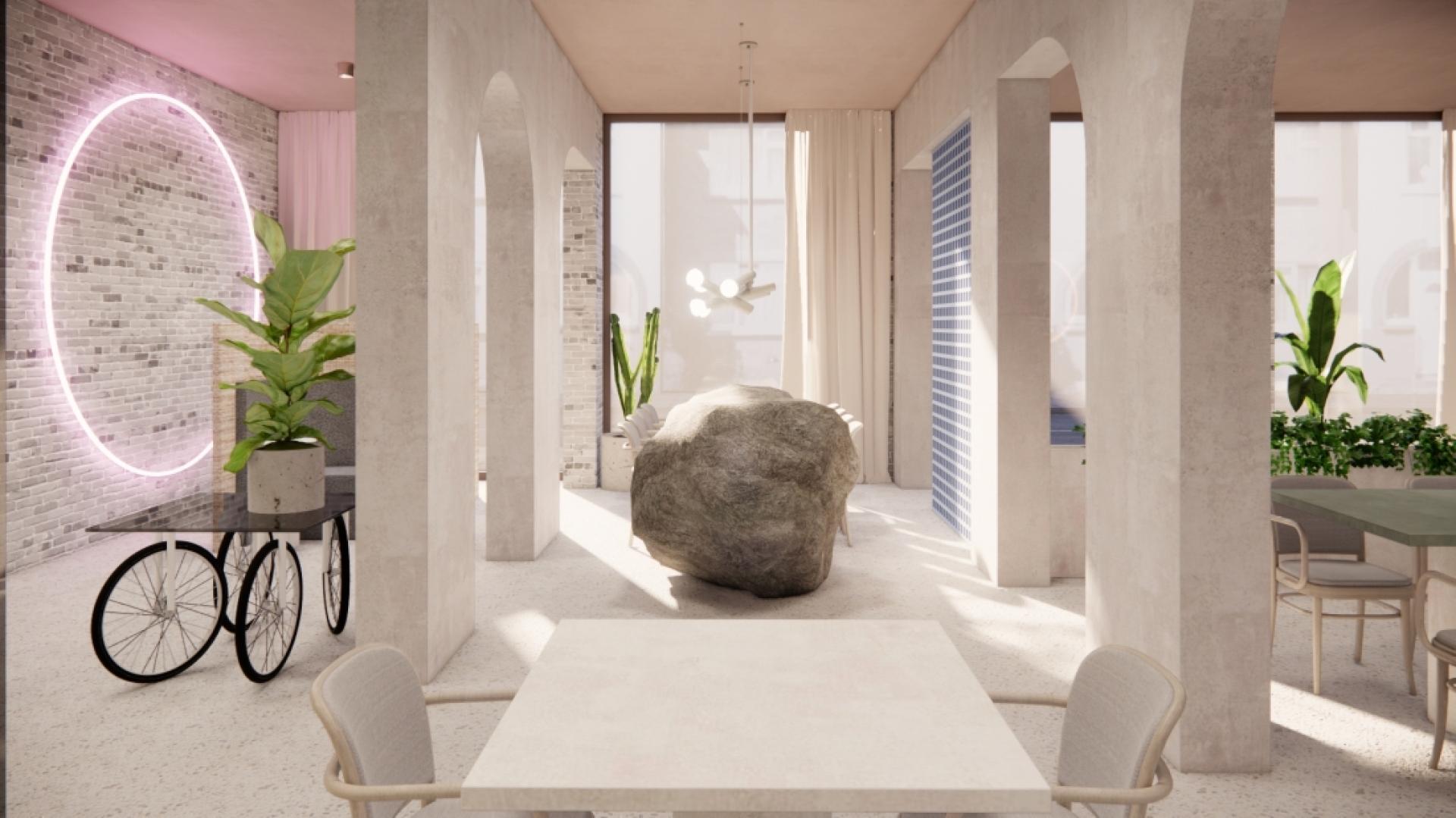 Modern interior design featuring a large stone centerpiece, plants, and unique lighting in a vibrant workspace.