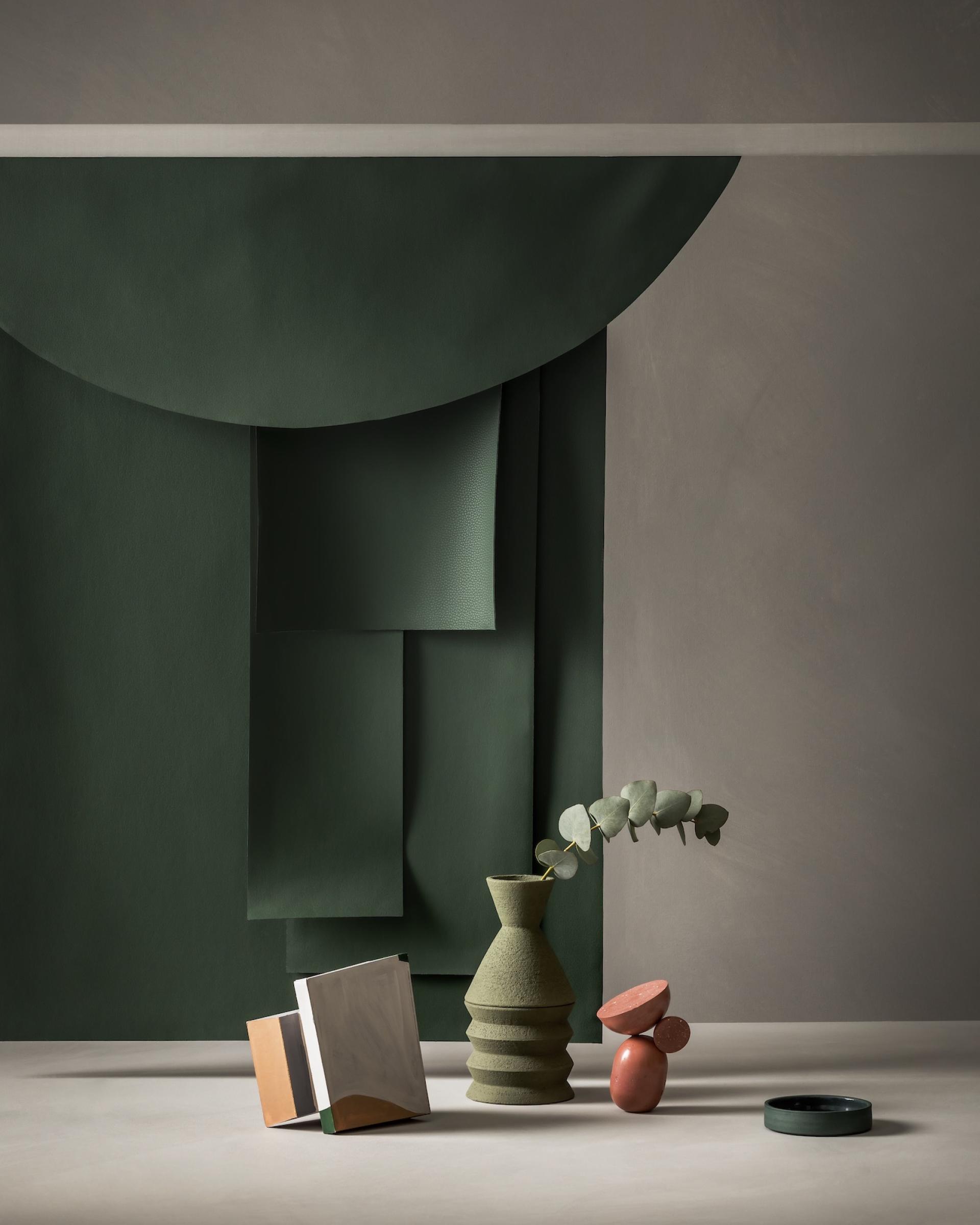 Stylish composition featuring earth-toned ceramics and foliage against a soft green backdrop, inspired by Ultrafabrics' Volar Bio range.