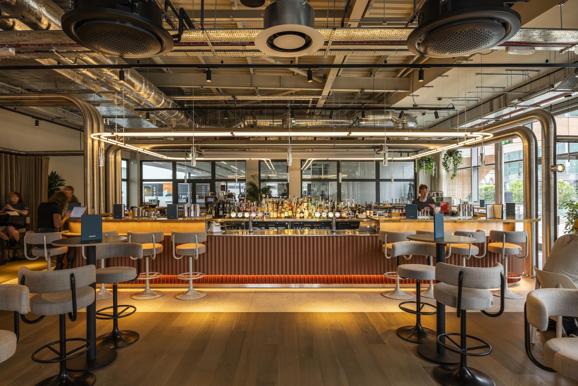 Stylish bar interior at Junction Manchester Central, featuring modern furnishings and a vibrant beverage selection.