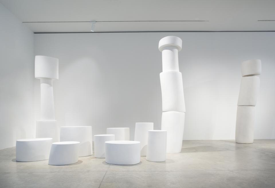 White sculptural furniture pieces by Wendell Castle displayed in a minimalist gallery setting, showcasing organic forms and design innovation.