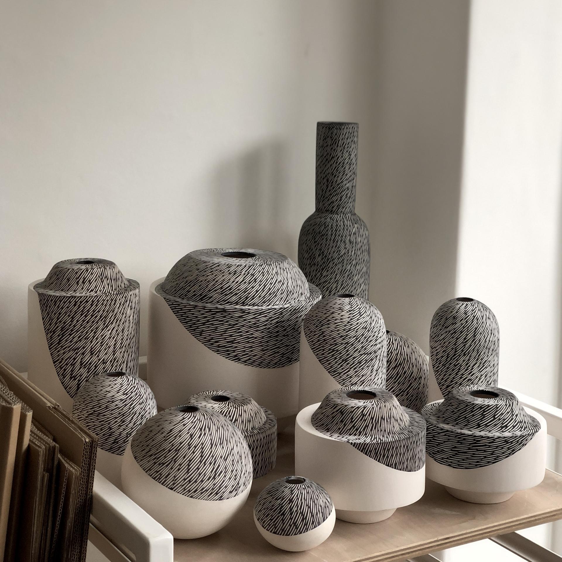 Handcrafted ceramic pieces by Sophie Farrar, showcasing unique black and white designs on various modern vases and bowls.