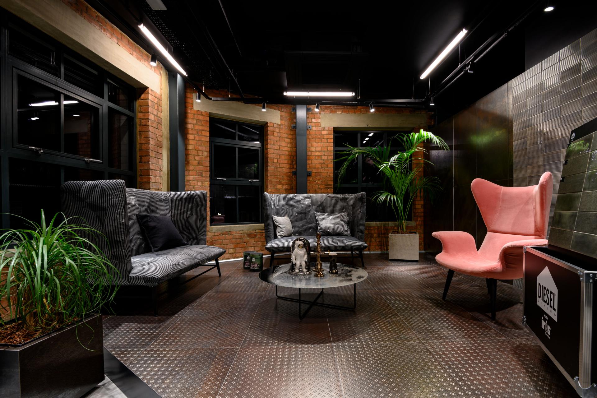 Modern showroom interior featuring stylish seating, decorative plants, and polished floors, showcasing Iris Ceramica Group's design aesthetic.