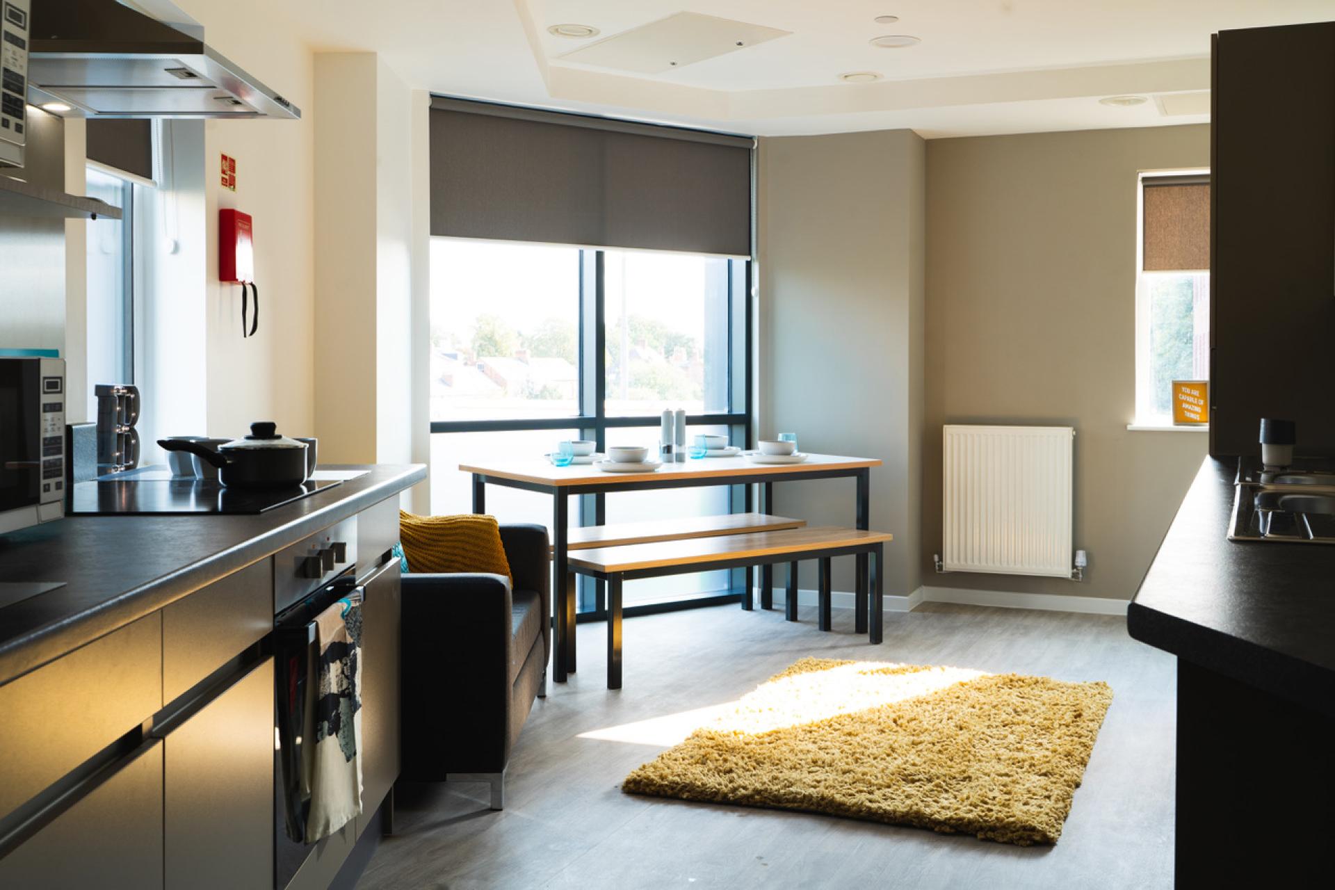 Modern student accommodation kitchen and dining area in Bath Court, Birmingham, featuring stylish furnishings and ample natural light.
