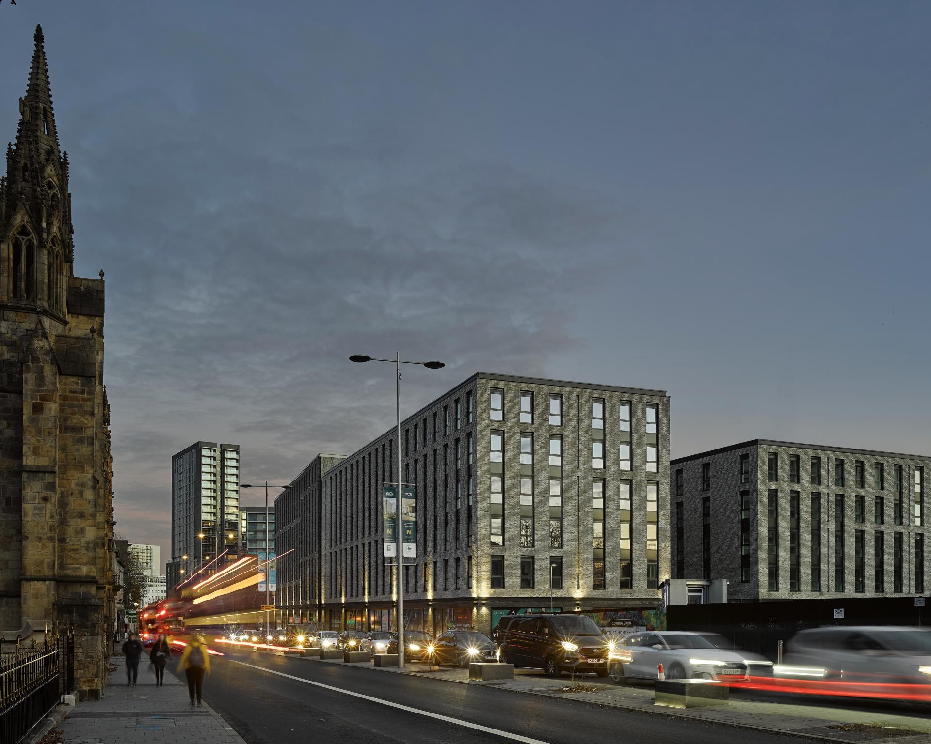 Modern urban landscape featuring Buttress buildings, highlighted by evening traffic and historic architecture.