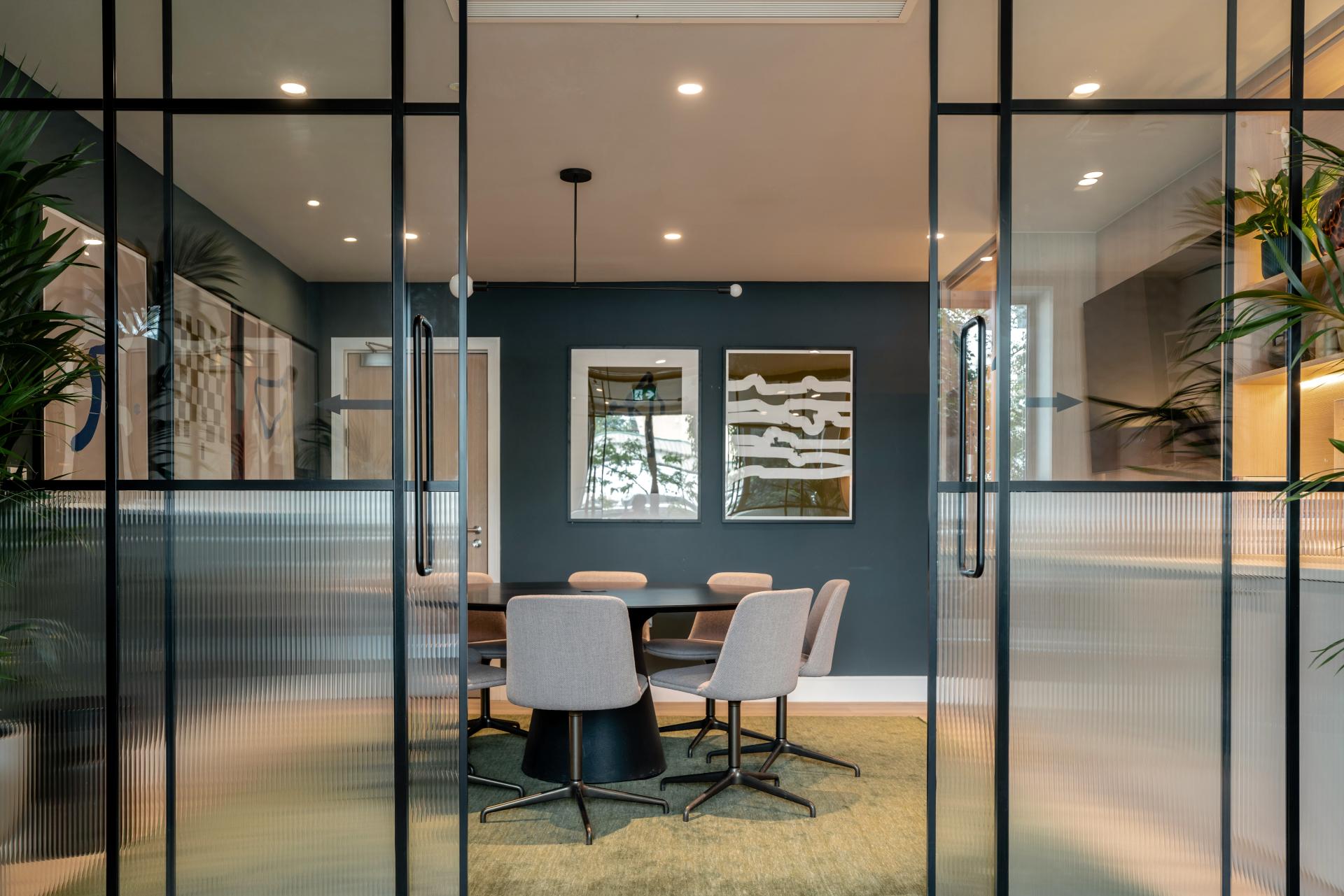 Stylish co-living space interior featuring modern furniture, artwork, and greenery, designed by Ekho Studio in The Apiary.