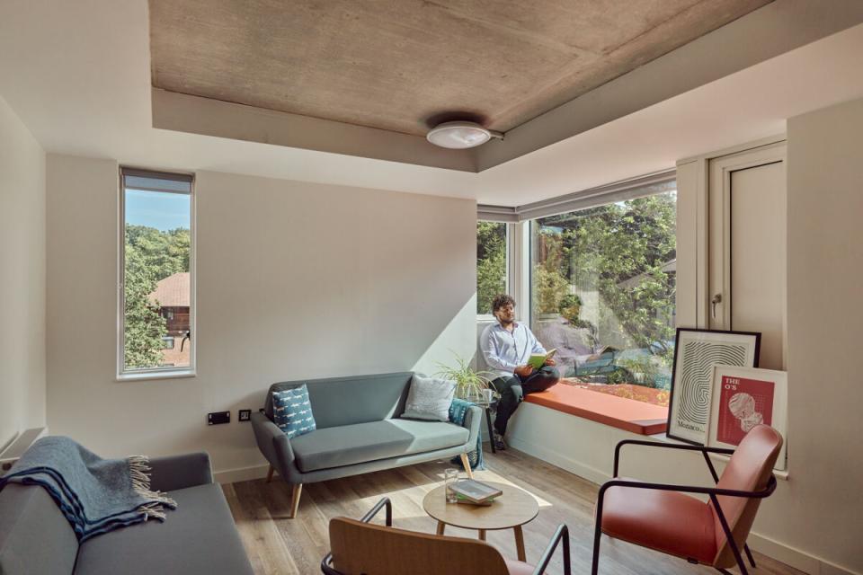 Modern student accommodation interior at Oxford Brookes University featuring a cozy seating area and large windows.