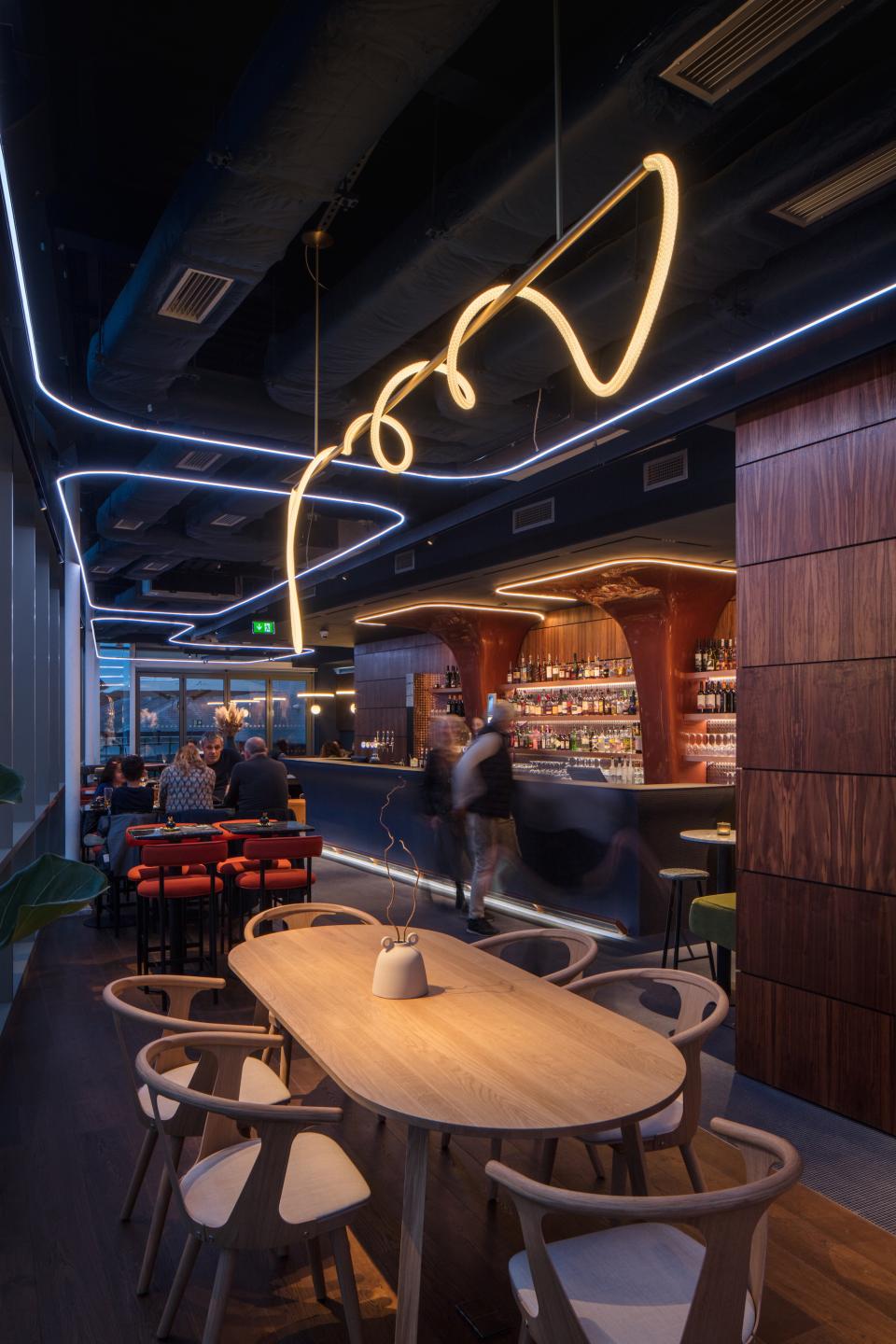 Stylish interior of M'Arks Sky Bar in London, featuring modern lighting, elegant furnishings, and a vibrant bar atmosphere.