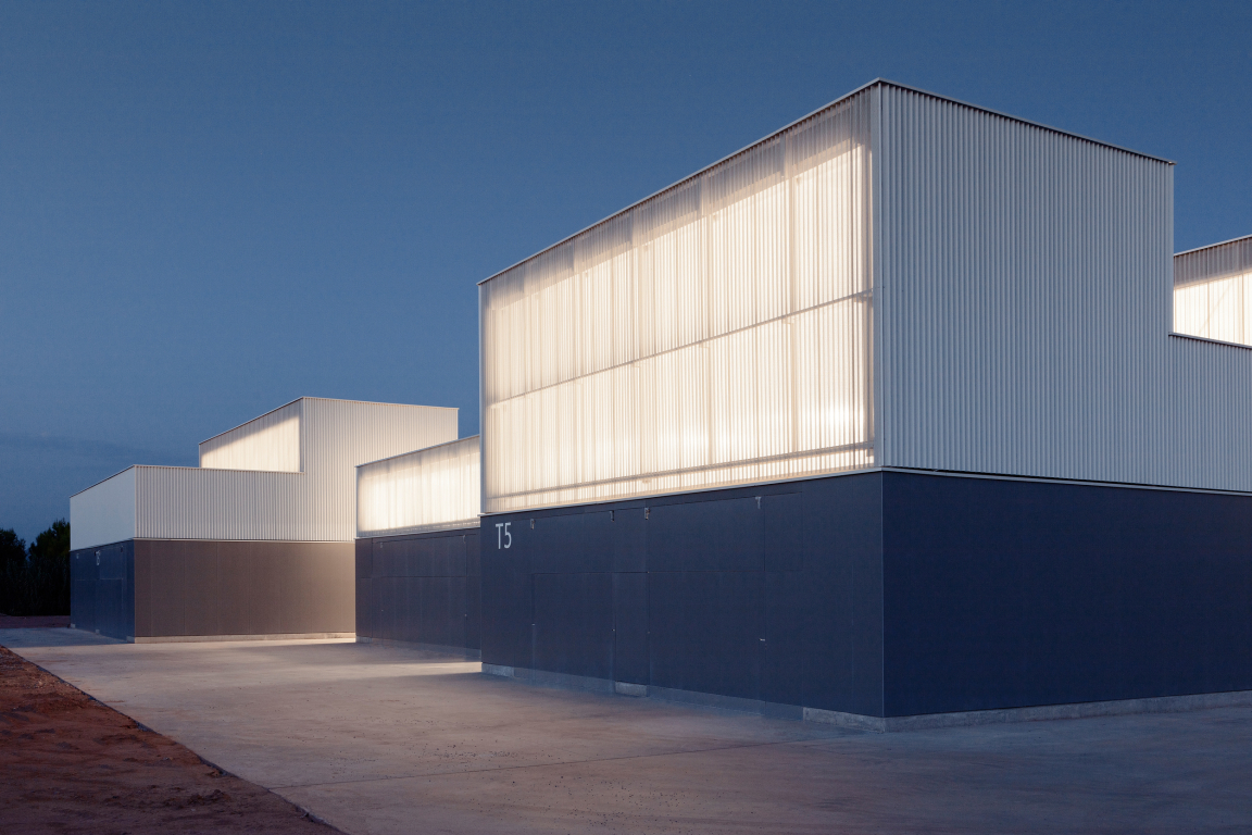Modern architectural building showcasing innovative ceramic design elements illuminated at dusk.