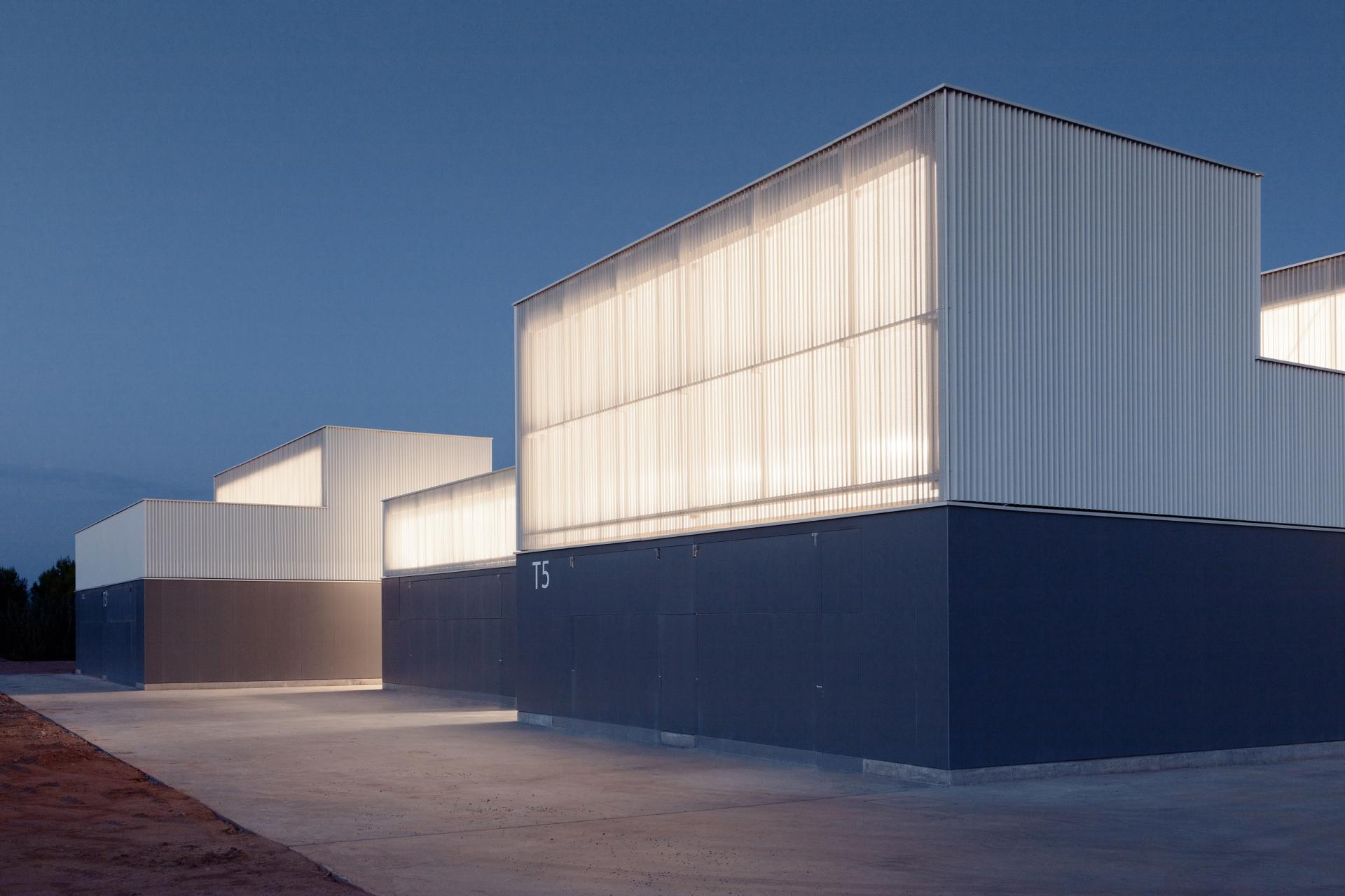 Modern architectural building showcasing innovative ceramic design elements illuminated at dusk.