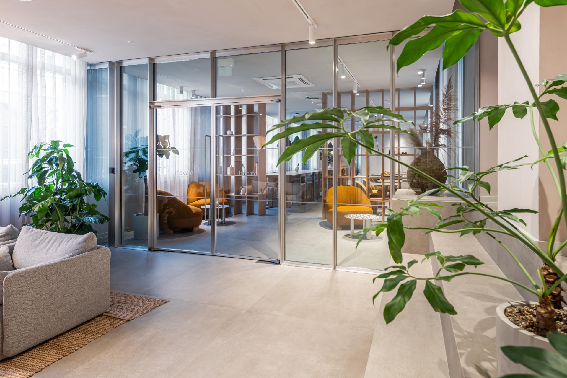Modern flexible workspace interior featuring glass partitions, cozy seating areas, and lush greenery in Holborn's Chancery House.
