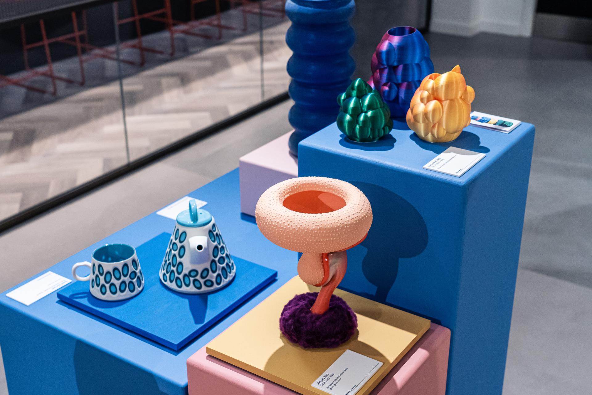 Colorful sculptures and ceramics displayed on platforms at the Makers in Residence showcase in Material Source Studio, Glasgow.