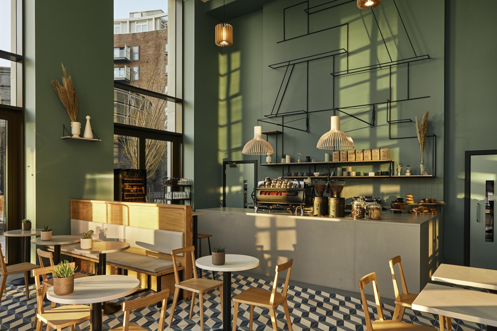 Modern café interior at Material Source Studio Glasgow with stylish decor, seating, and an espresso machine.