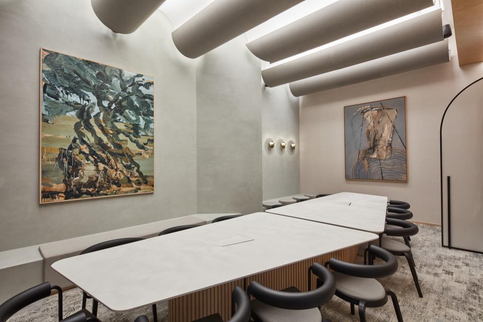 Modern meeting room at Roar Studio in Dubai, featuring abstract artwork, sleek furniture, and natural lighting.