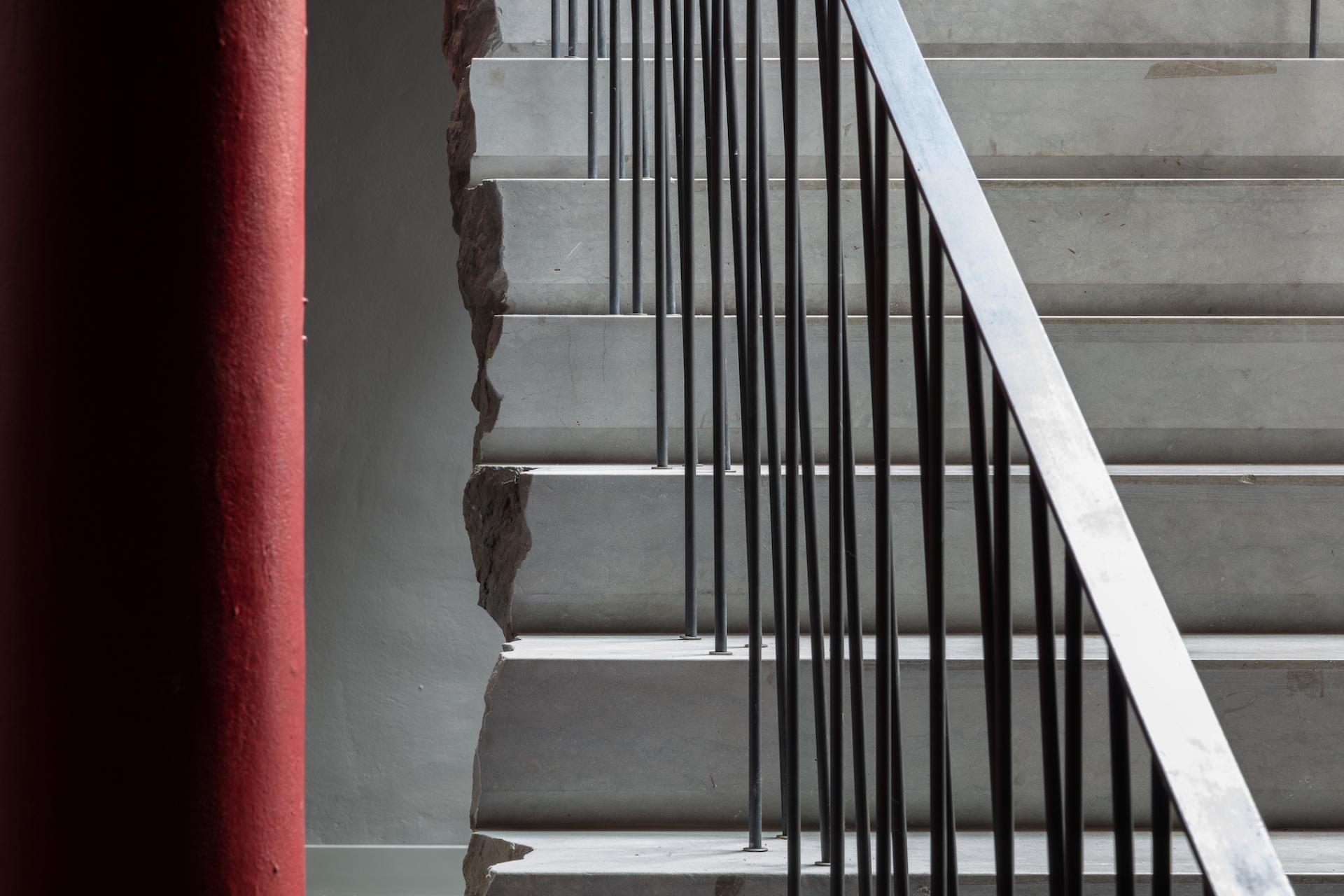 Modern concrete stairs with black railings lead up in Holloway Li's Clerkenwell showroom and co-working space.