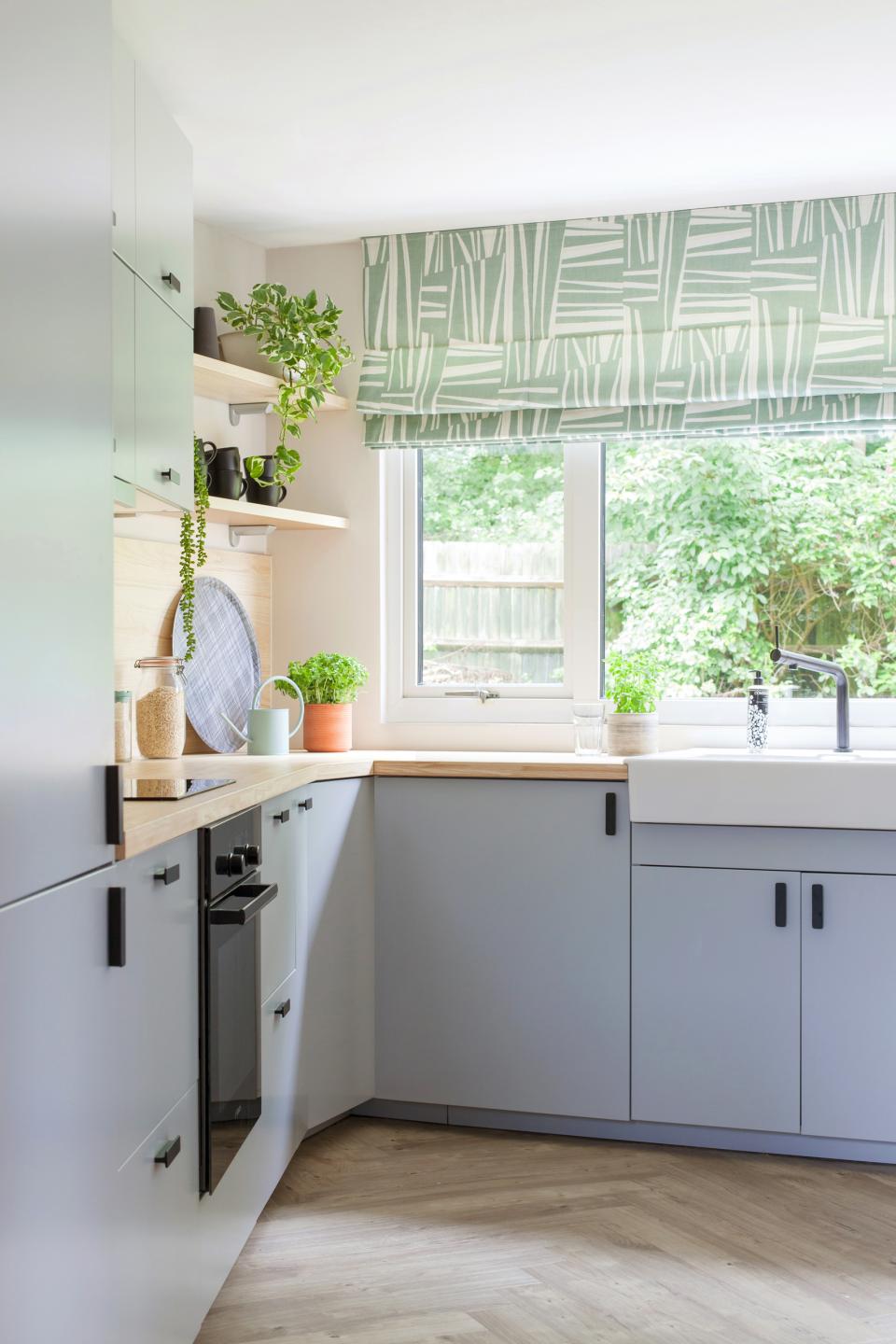 Modern Scandi Industrial kitchen featuring sleek cabinetry, natural wooden countertops, and lush greenery for a fresh aesthetic.