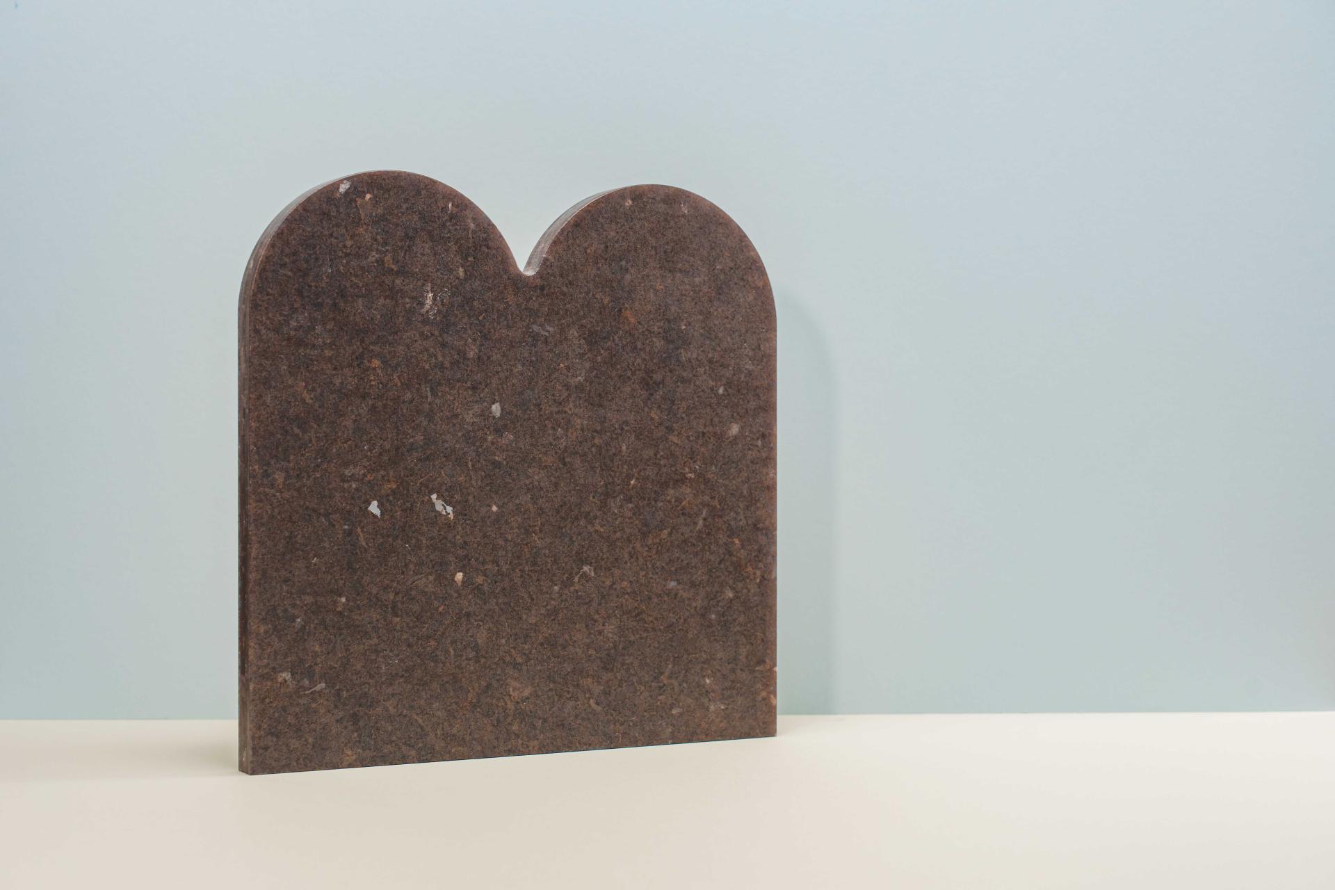 Brown, curved sculptural piece from Smile Plastics’ Earth Collection, inspired by the Welsh landscape, displayed against a light background.