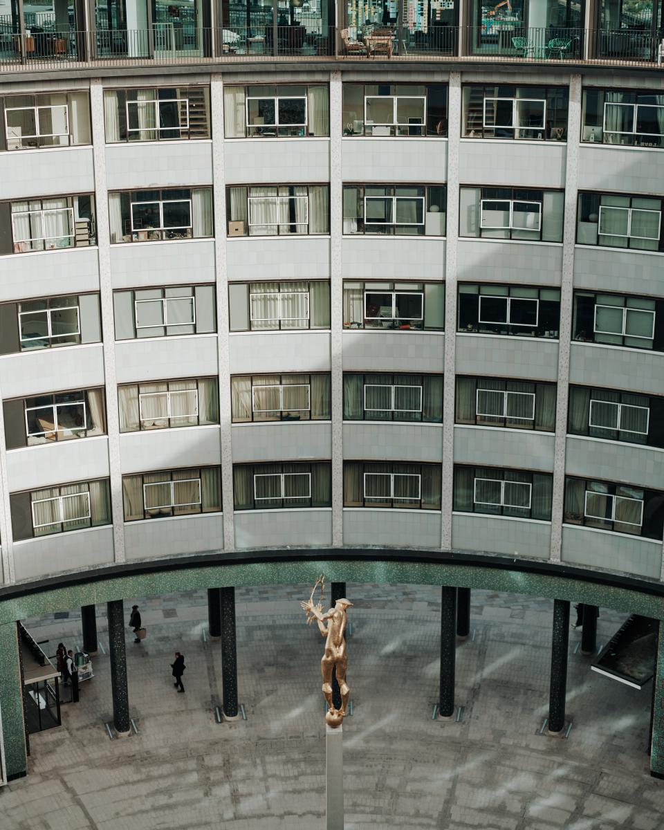 Elegant interiors of Helios 710 at Television Centre, featuring a prominent golden statue amidst modern architectural design.