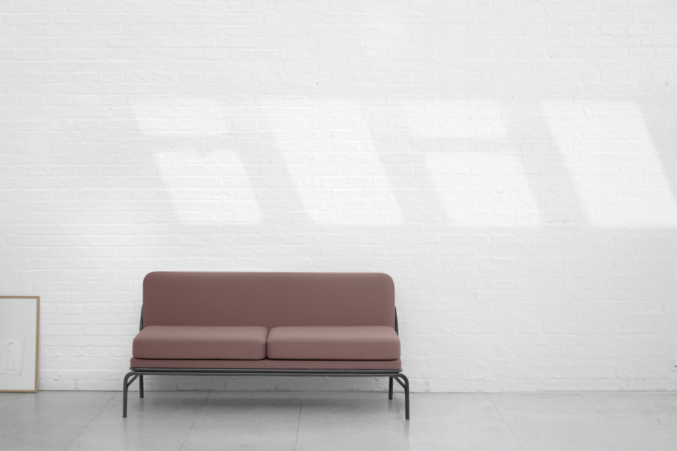 Minimalist two-seat sofa from the Nudo Collection by OGSB Studio, featuring sleek lines and a soft pink hue.