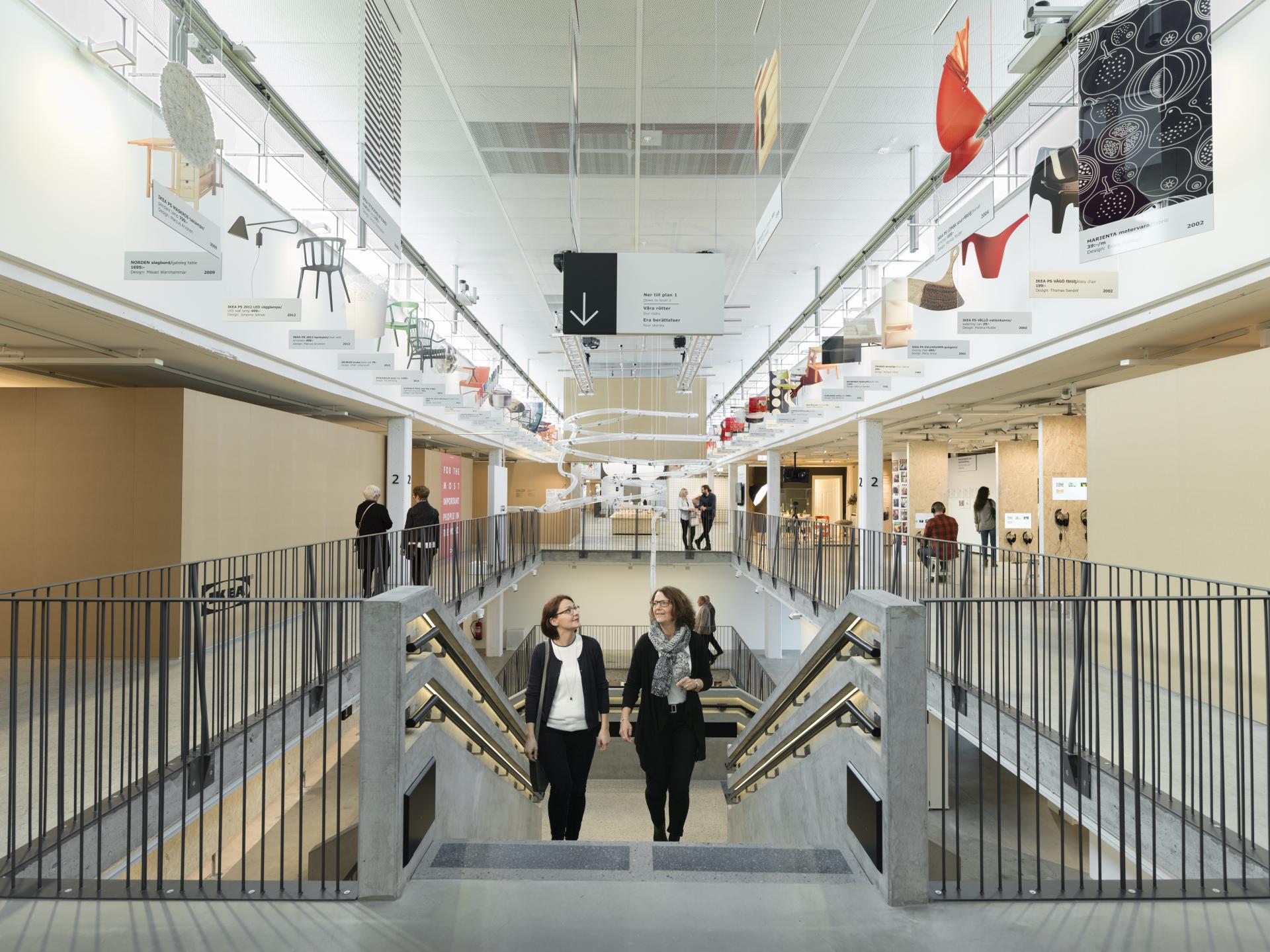 Visitors exploring the IKEA Museum in Älmhult, admiring innovative furniture displays and historic design elements.