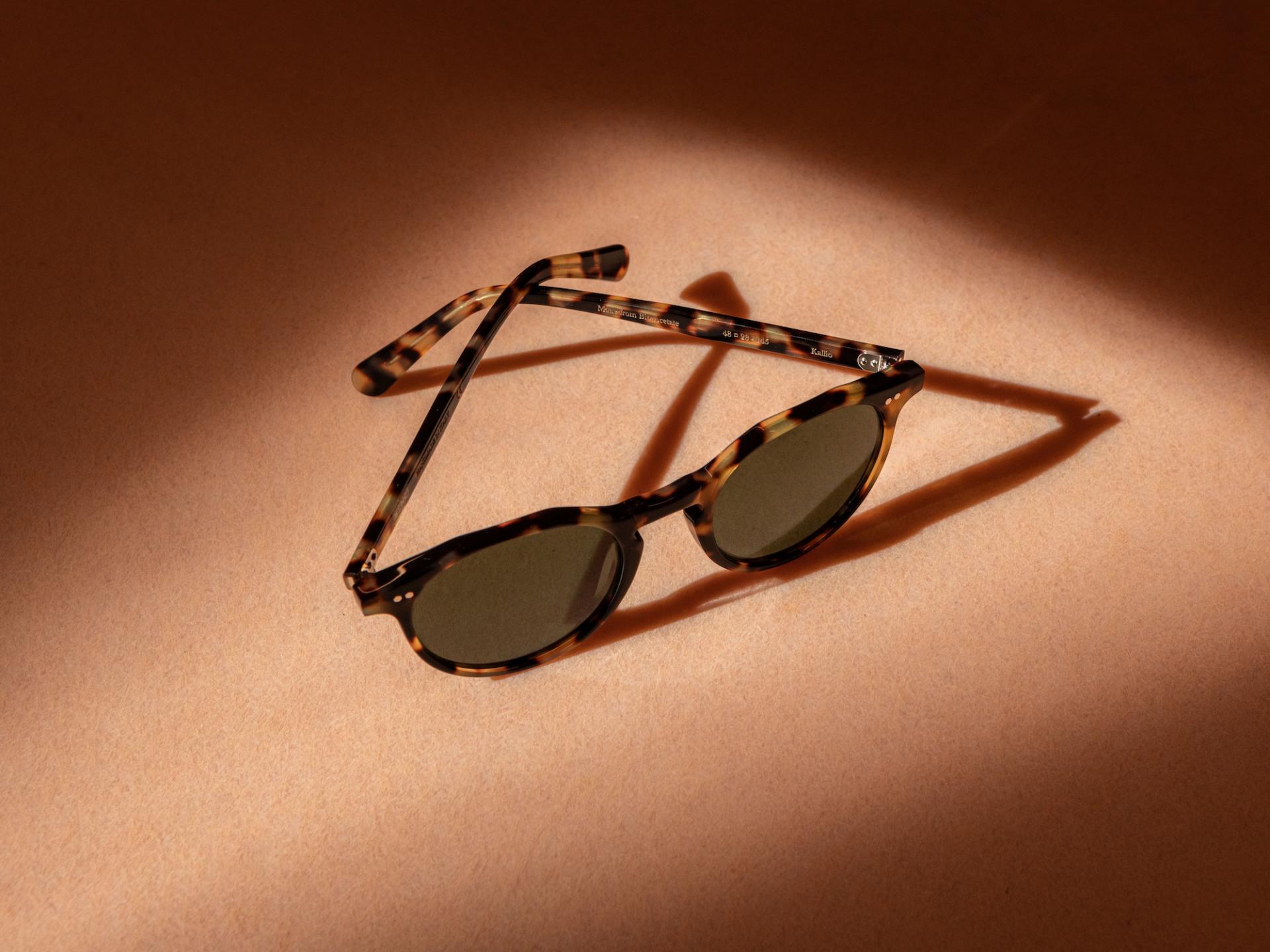 Stylish tortoiseshell sunglasses on a soft surface, highlighting MONC's eco-friendly eyewear collection.