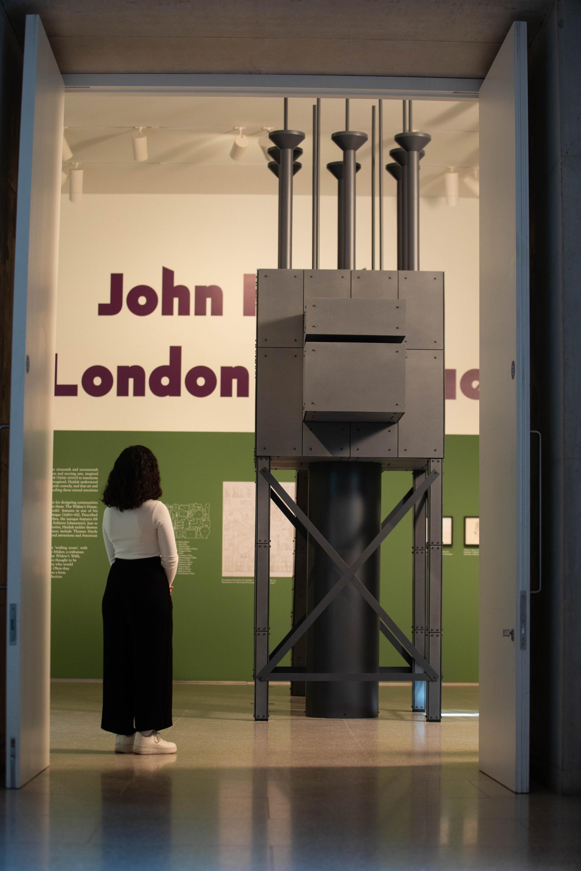 A visitor examines a large architectural model at the 'John Hejduk: London Masque' exhibition in the Royal Academy of Arts.