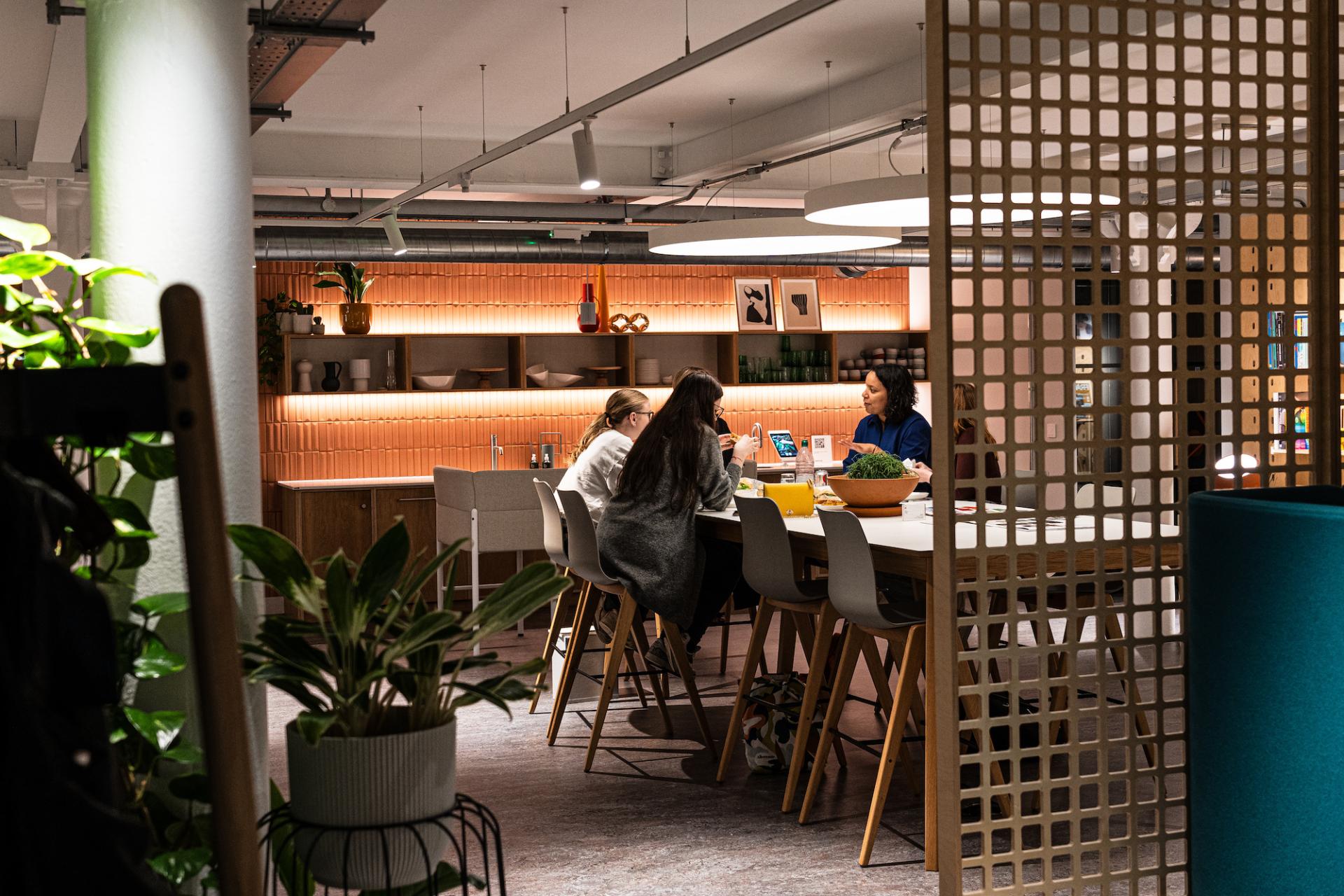 Collaborative workspace at Material Source Studio Glasgow, featuring designers engaging in discussion around a modern table.
