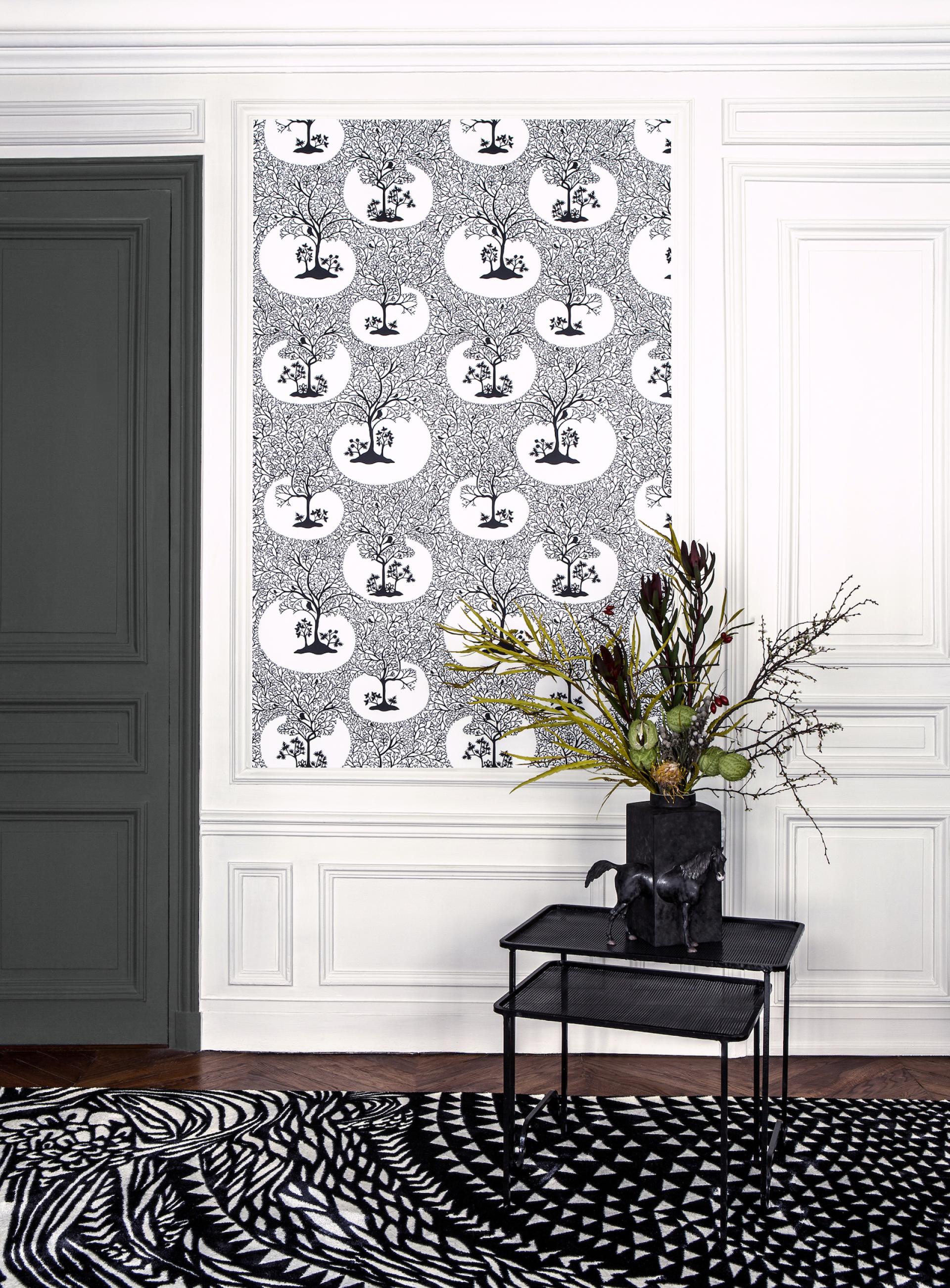 Stylish interior featuring Christian Lacroix-inspired capsule wallpaper with intricate tree designs, accented by modern furniture and decor.