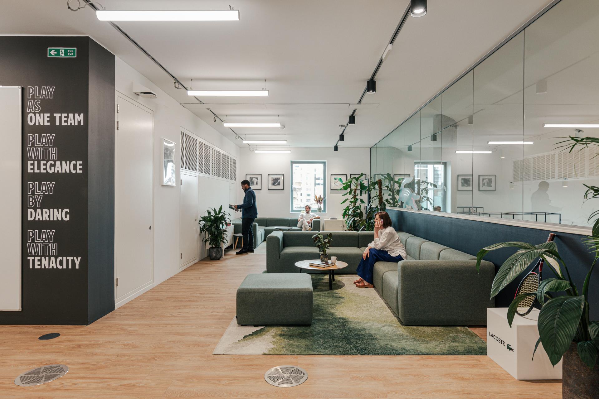 Modern London workspace for Lacoste Shoes featuring a green color palette, stylish seating, and motivational wall decor.