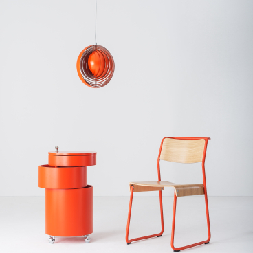 Vibrant red furniture including a modern light fixture and stylish chair, reflecting designjunction's (Re)act theme for this year's show.