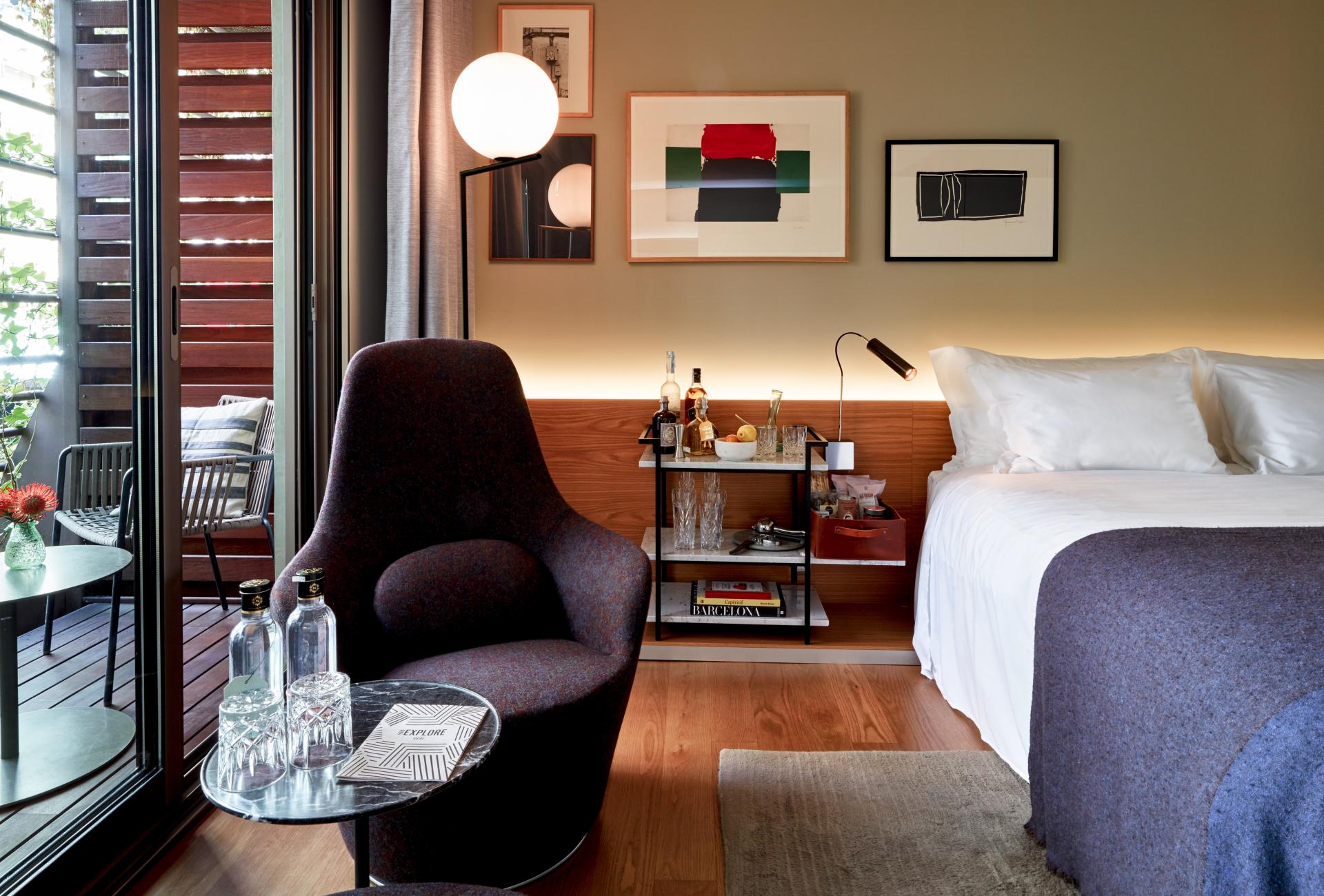 Stylish hotel room at Sir Victor in Barcelona, featuring contemporary decor, a cozy chair, and a welcoming atmosphere.