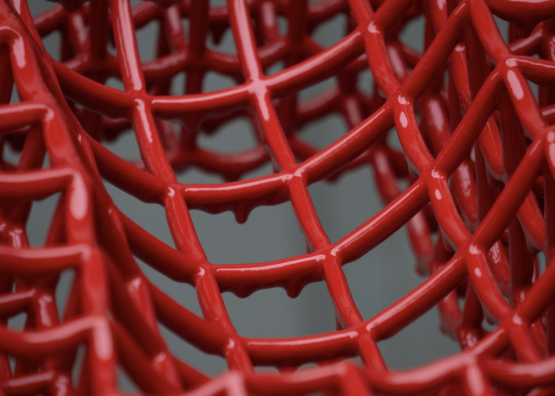 Intricate red ceramic lattice structure showcasing innovative Dutch design techniques highlighted at Dutch Design Week 2024.