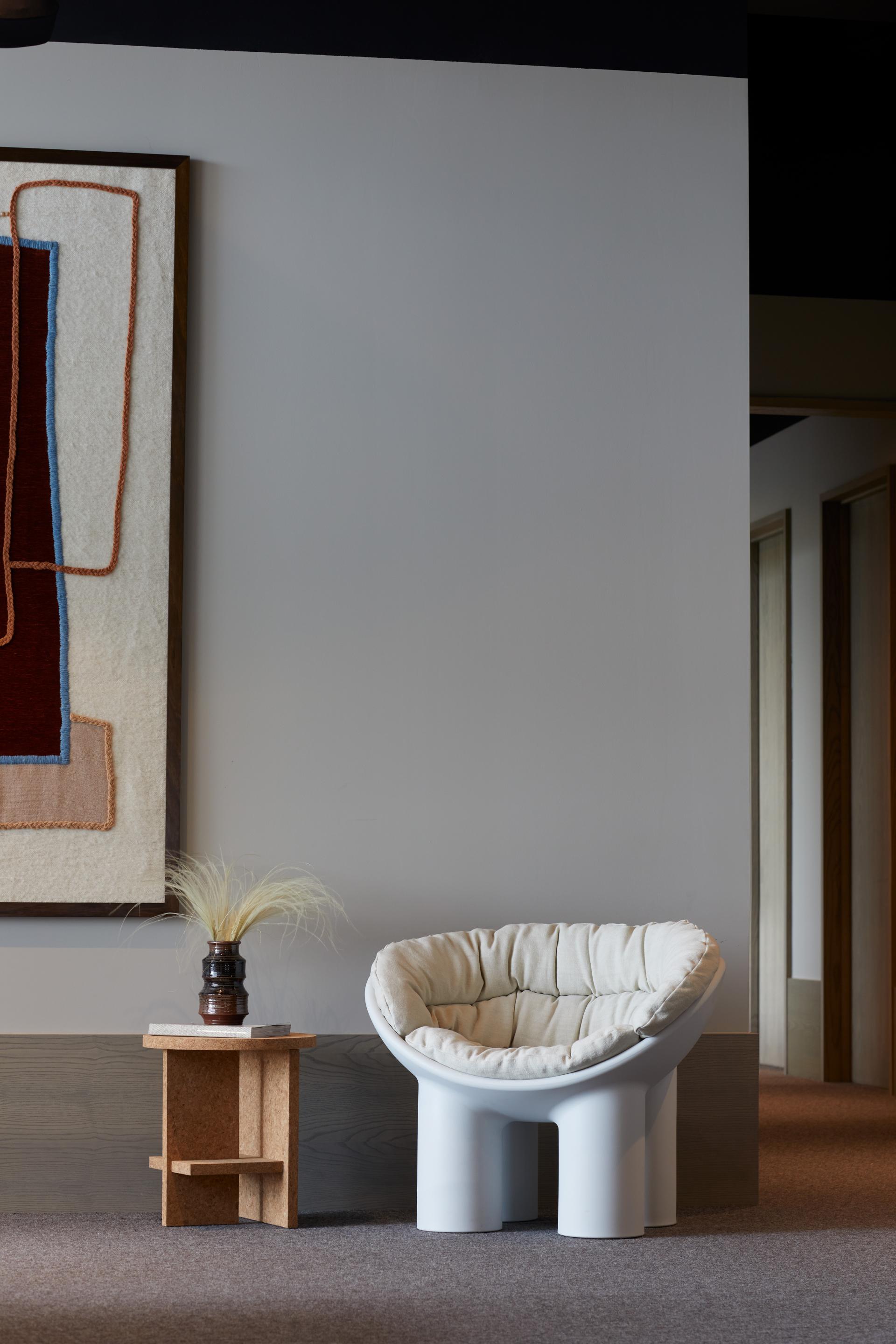 Modern lounge area in The Office Group's Notting Hill workspace, featuring a unique chair and decorative artwork.