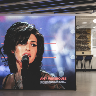 Large wall screen displaying a portrait of Amy Winehouse in a music-themed workspace designed by Ekho Studio.