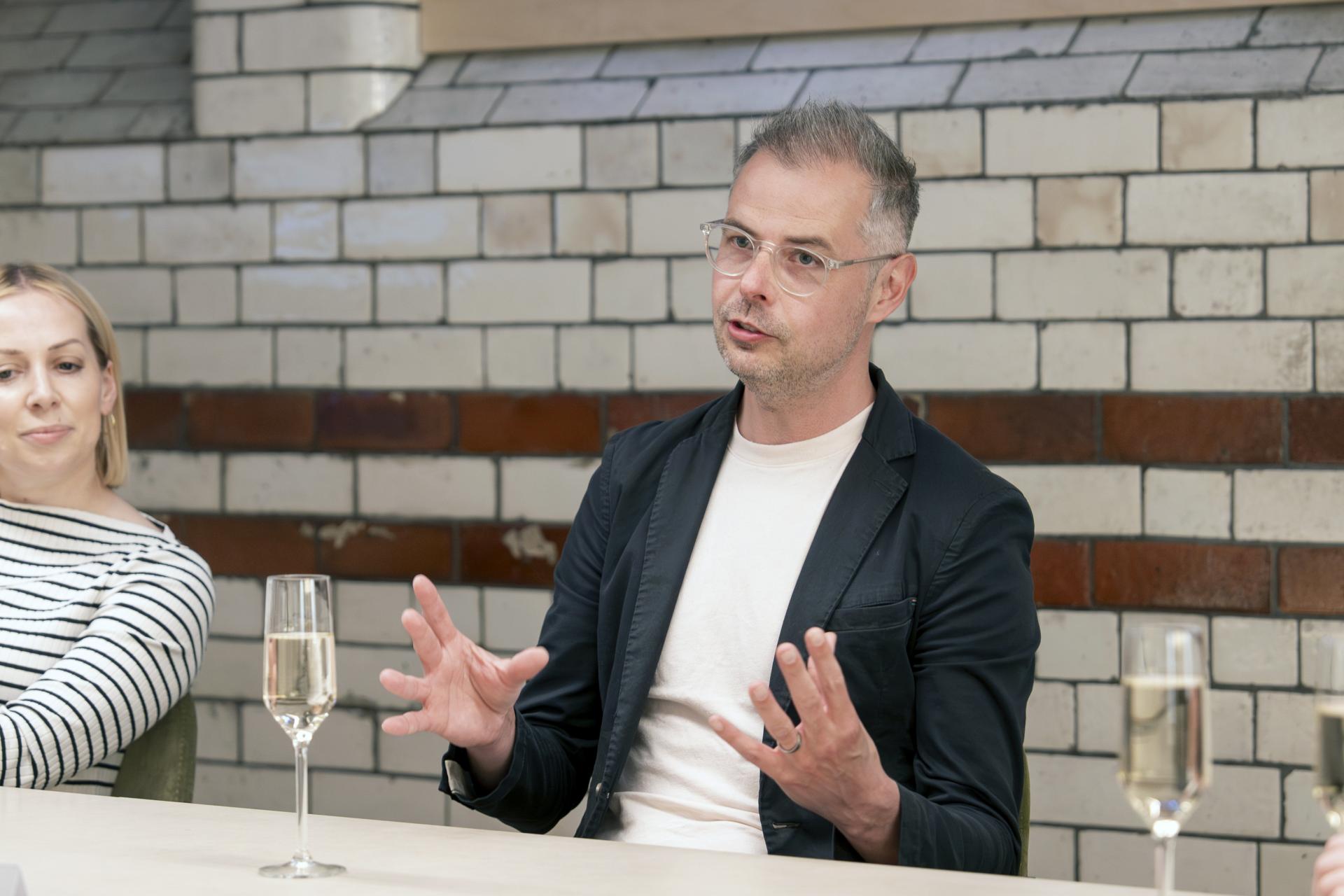 Discussion on Manchester's residential mix at a roundtable, featuring participants engaged in conversation.