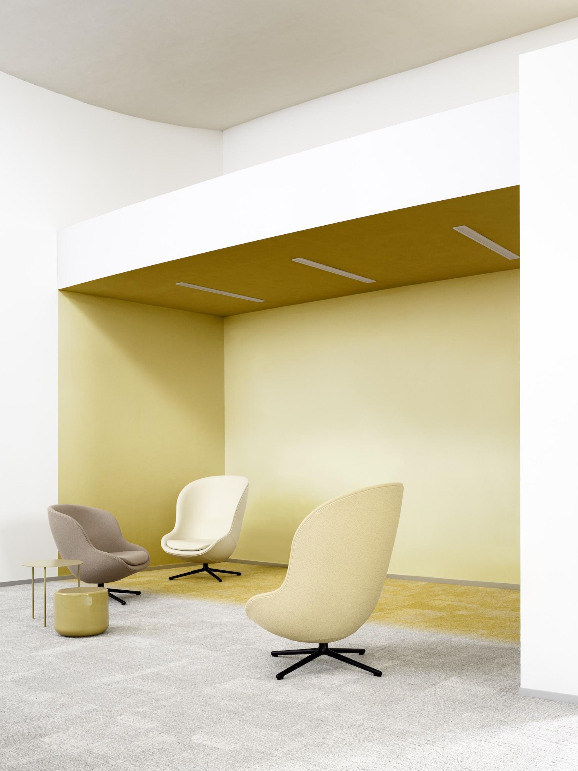 Modern seating in muted tones, highlighting Ege Carpets' ReForm Transition collection's nature-inspired design and architectural elegance.