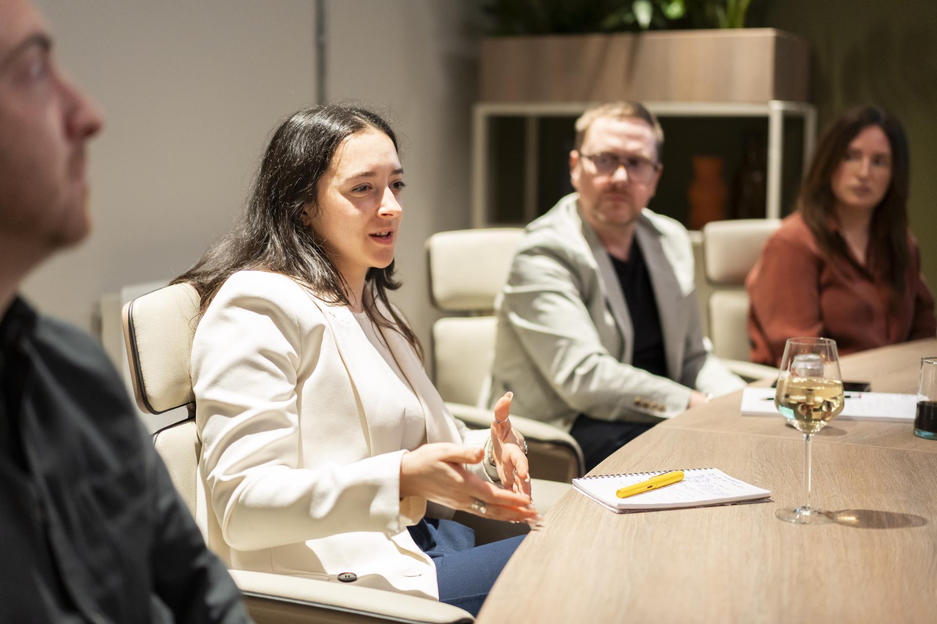 Participants discuss the role of technology in promoting sustainability within design during a collaborative meeting.
