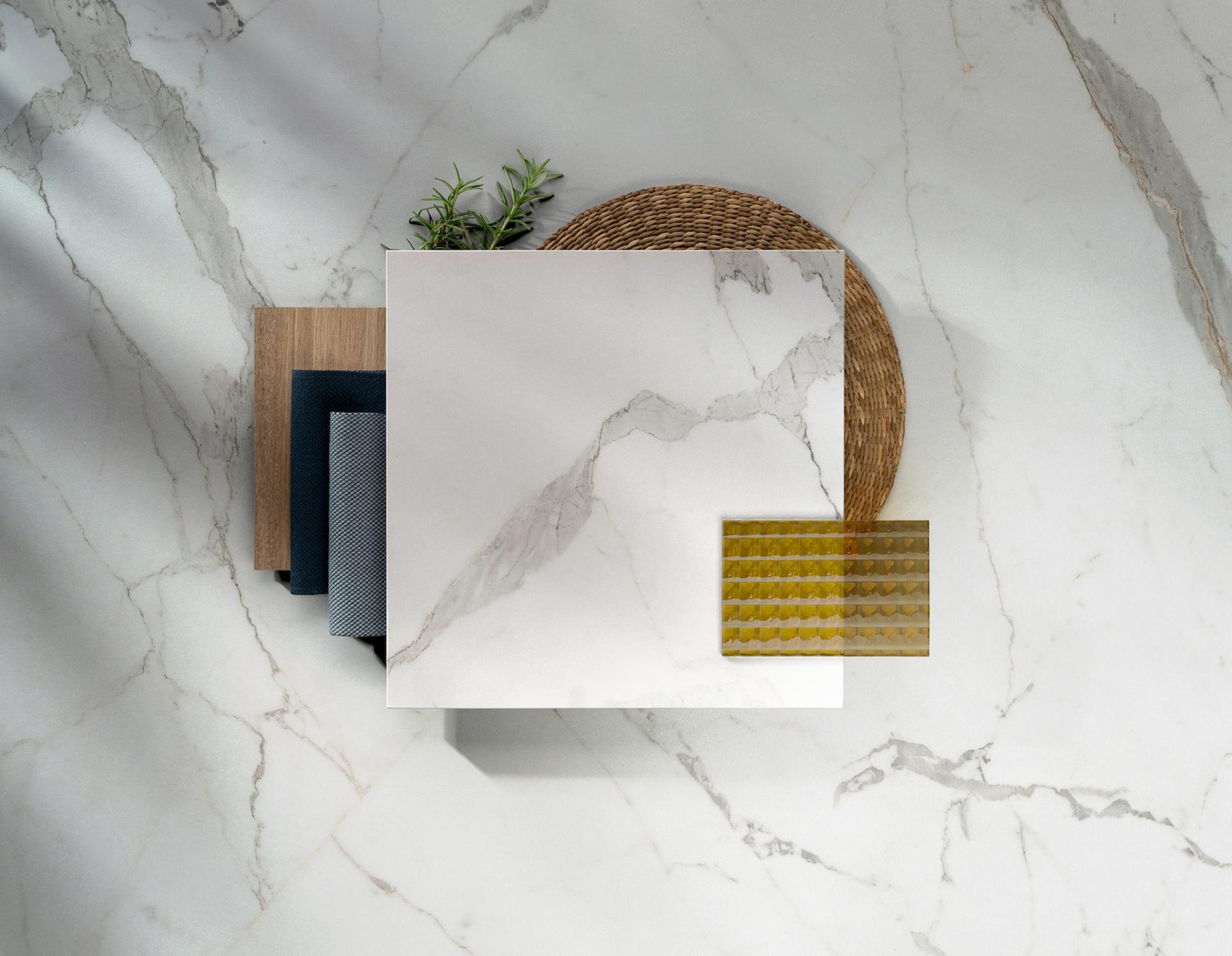 Dekton® surface samples alongside textile swatches and a decorative woven plate on a marble background.