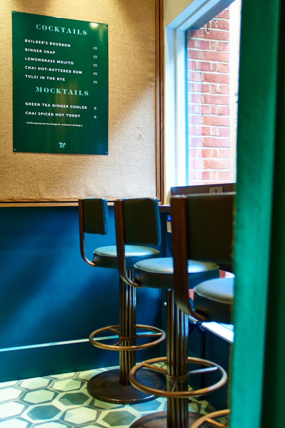 Stylish bar stools with a cocktail menu, showcasing art deco design in Teatulia's tea shop and cocktail bar.